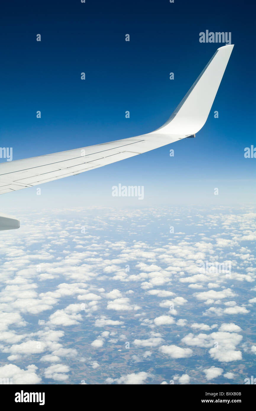 Boeing 737-800 de l'aile voler au-dessus de nuages dans le ciel bleu Banque D'Images