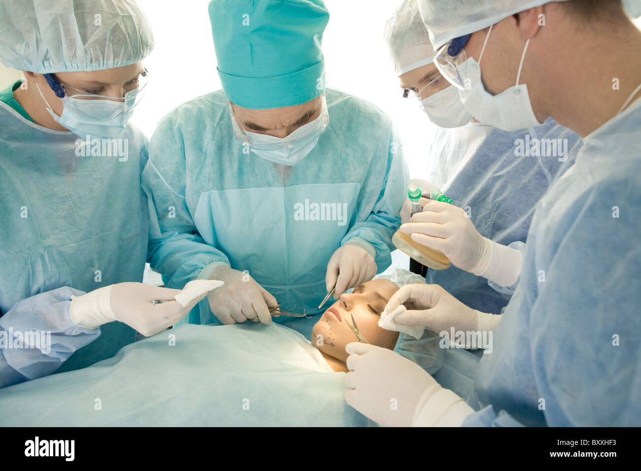 Droit de chirurgiens près de table d'opération avec le patient en cours de fonctionnement Banque D'Images