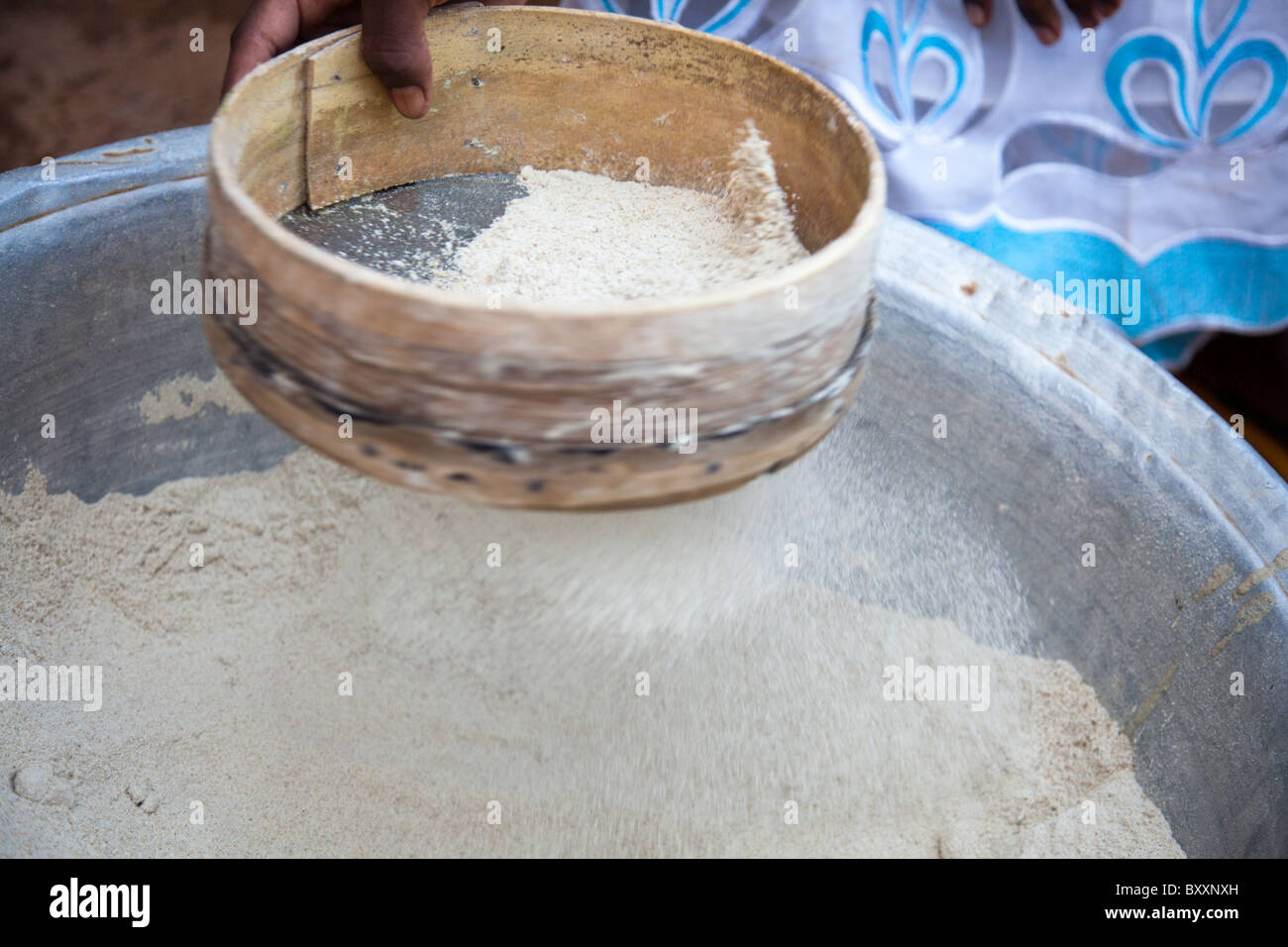 Une femme prépare la farine de mil pour la cuisson dans la ville de Djibo dans le nord du Burkina Faso. Banque D'Images