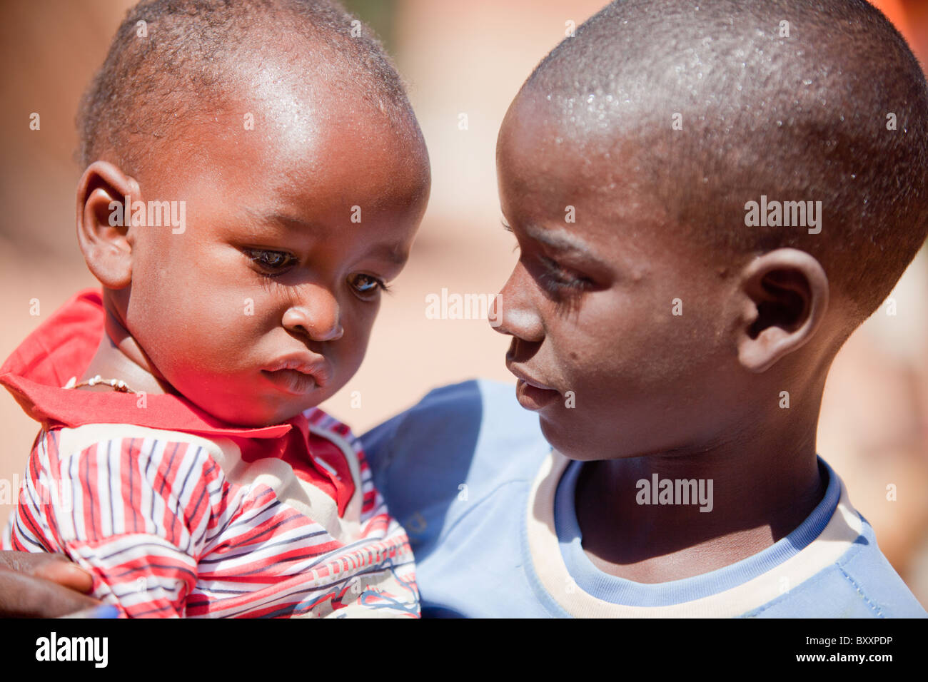 Un garçon Peul tient son jeune frère à Djibo, le nord du Burkina Faso. Banque D'Images