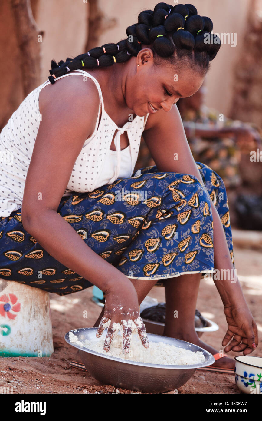 Une femme peule dans la ville de Djibo dans le nord du Burkina Faso, pétrit de farine de manioc, qu'elle va utiliser pour faire du couscous (attiéké-) Banque D'Images