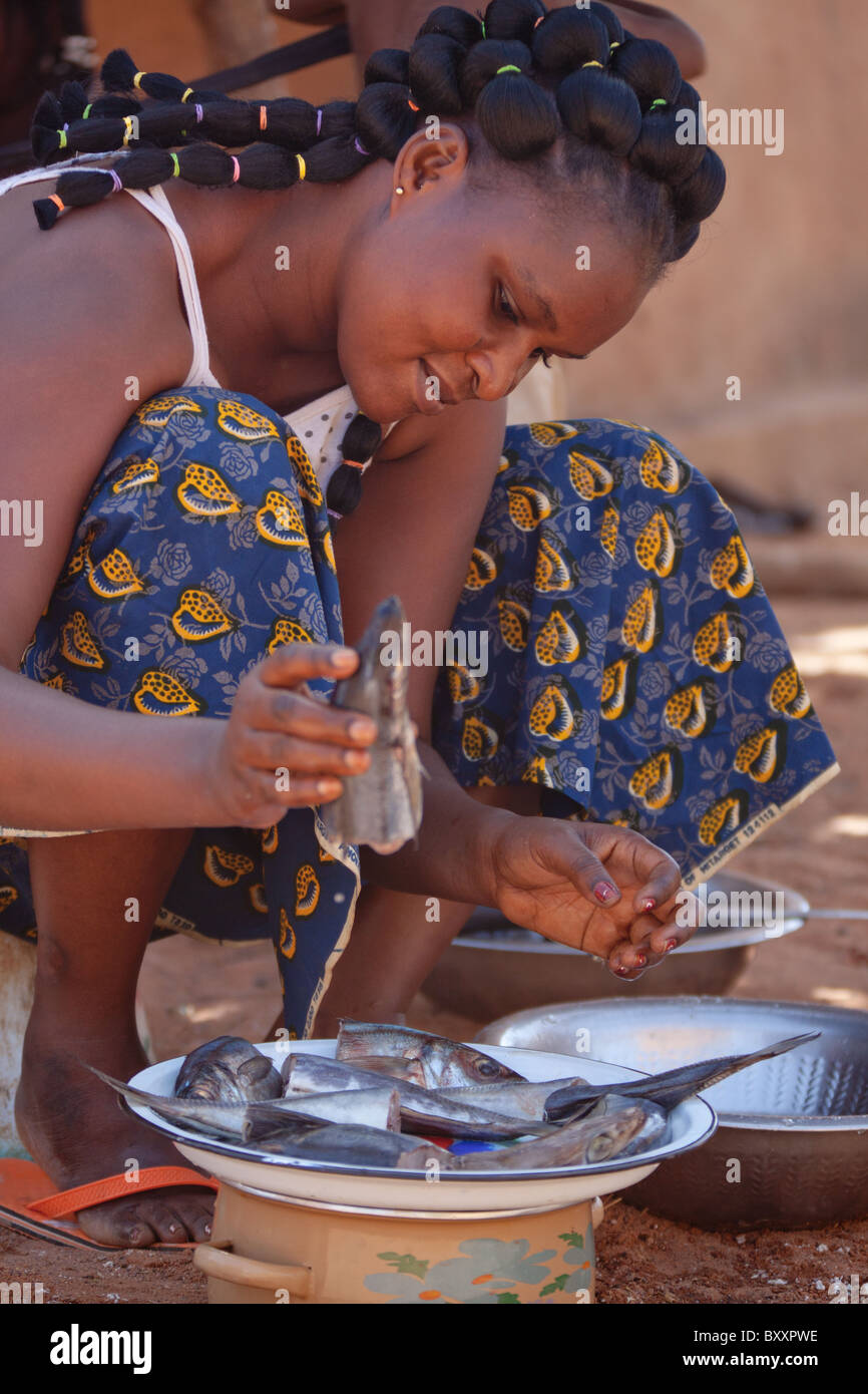 Une femme peule dans le nord du Burkina Faso, inspecte le poisson frais, qu'elle va faire frire et ajouter à un couscous de manioc (attiéké). Banque D'Images