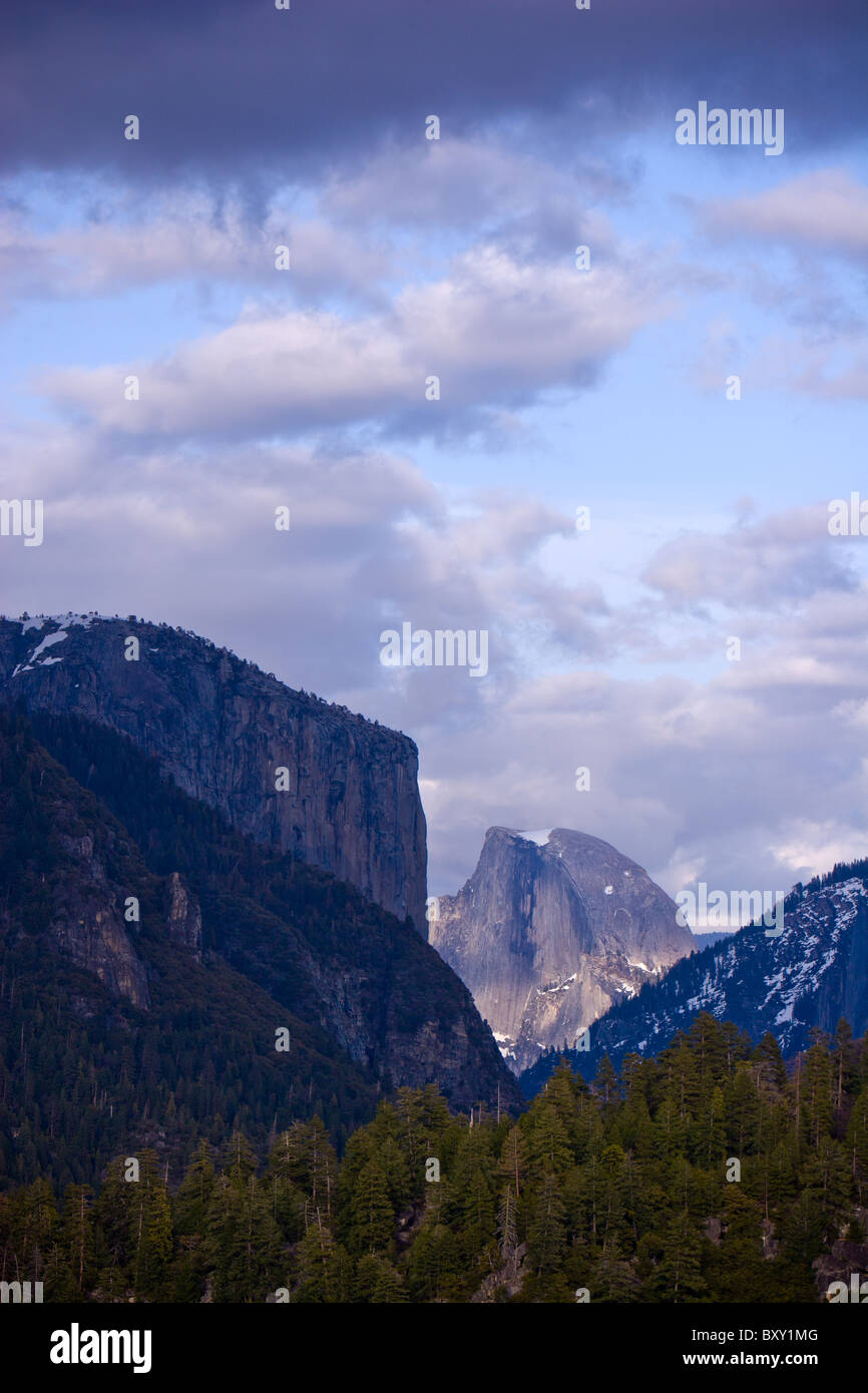 Une ombre passe au-dessus d'El Capitan, Half Dome, mais laisse à la lumière du soleil en Californie, le Parc National Yosemite. Banque D'Images