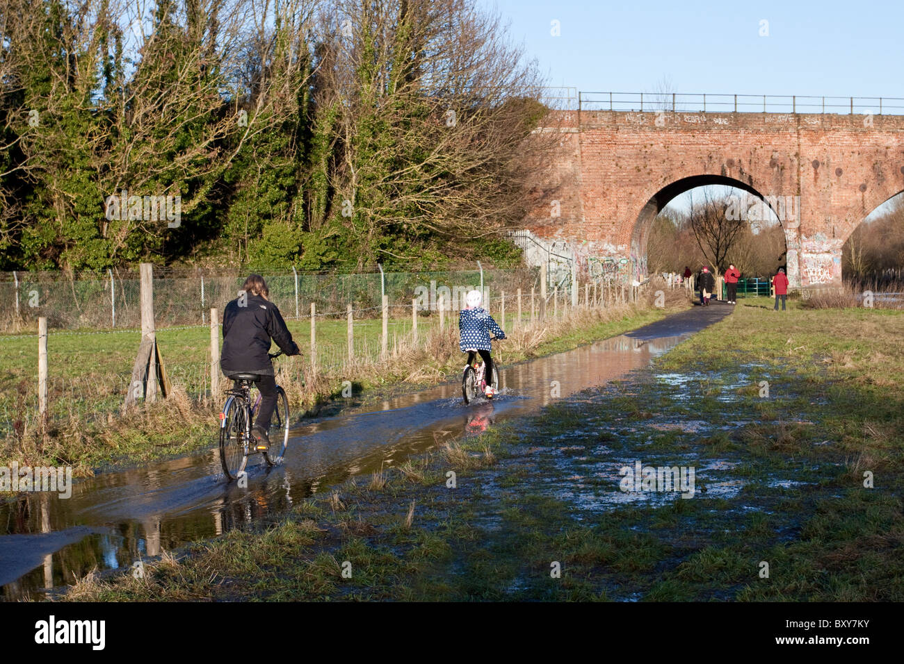 Les cyclistes la négociation d'une section de la nouvelle inondées à Canterbury Chartham sentier Riverside et piste cyclable. Banque D'Images