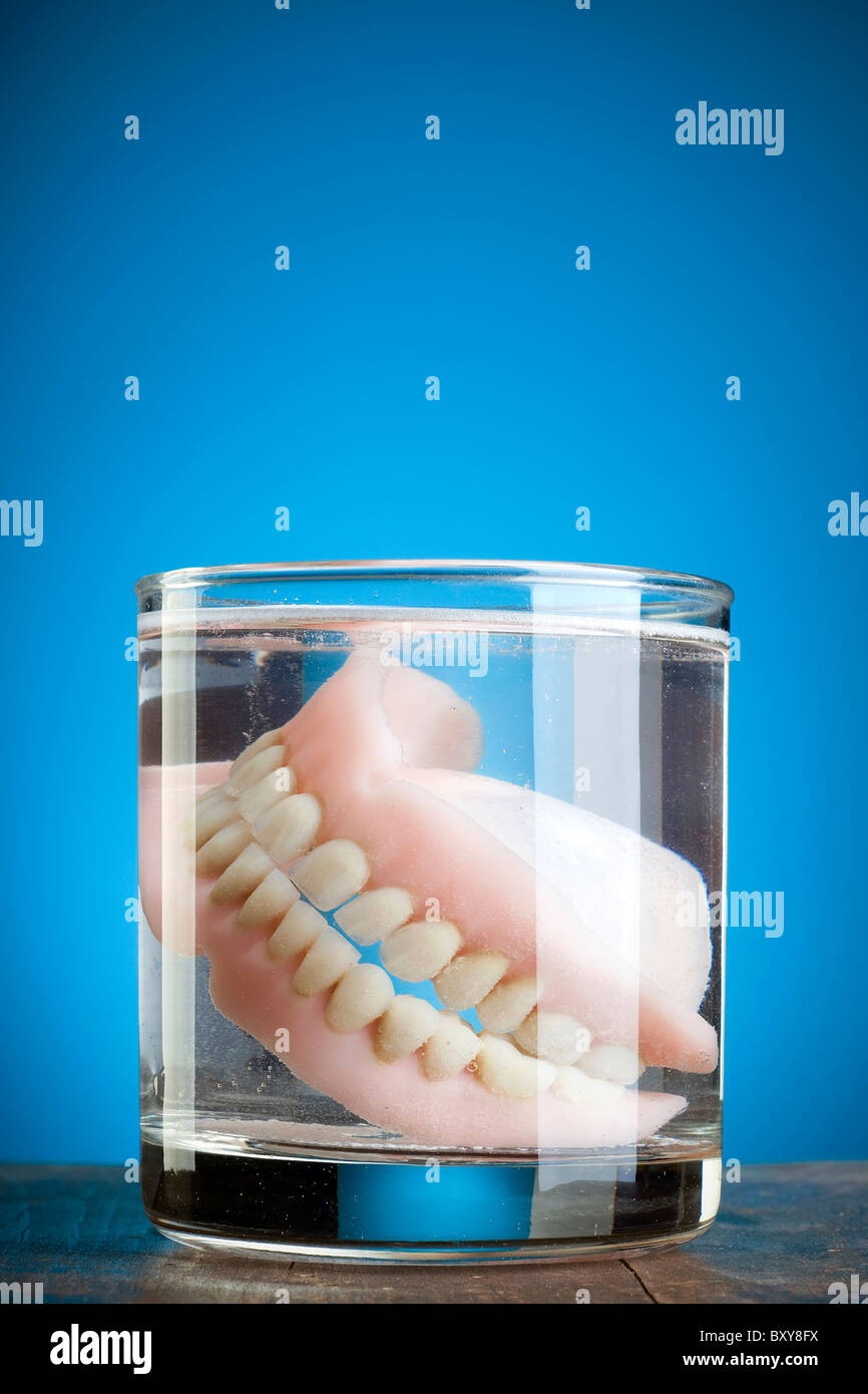 Une paire de dentier dans un verre d'eau Banque D'Images