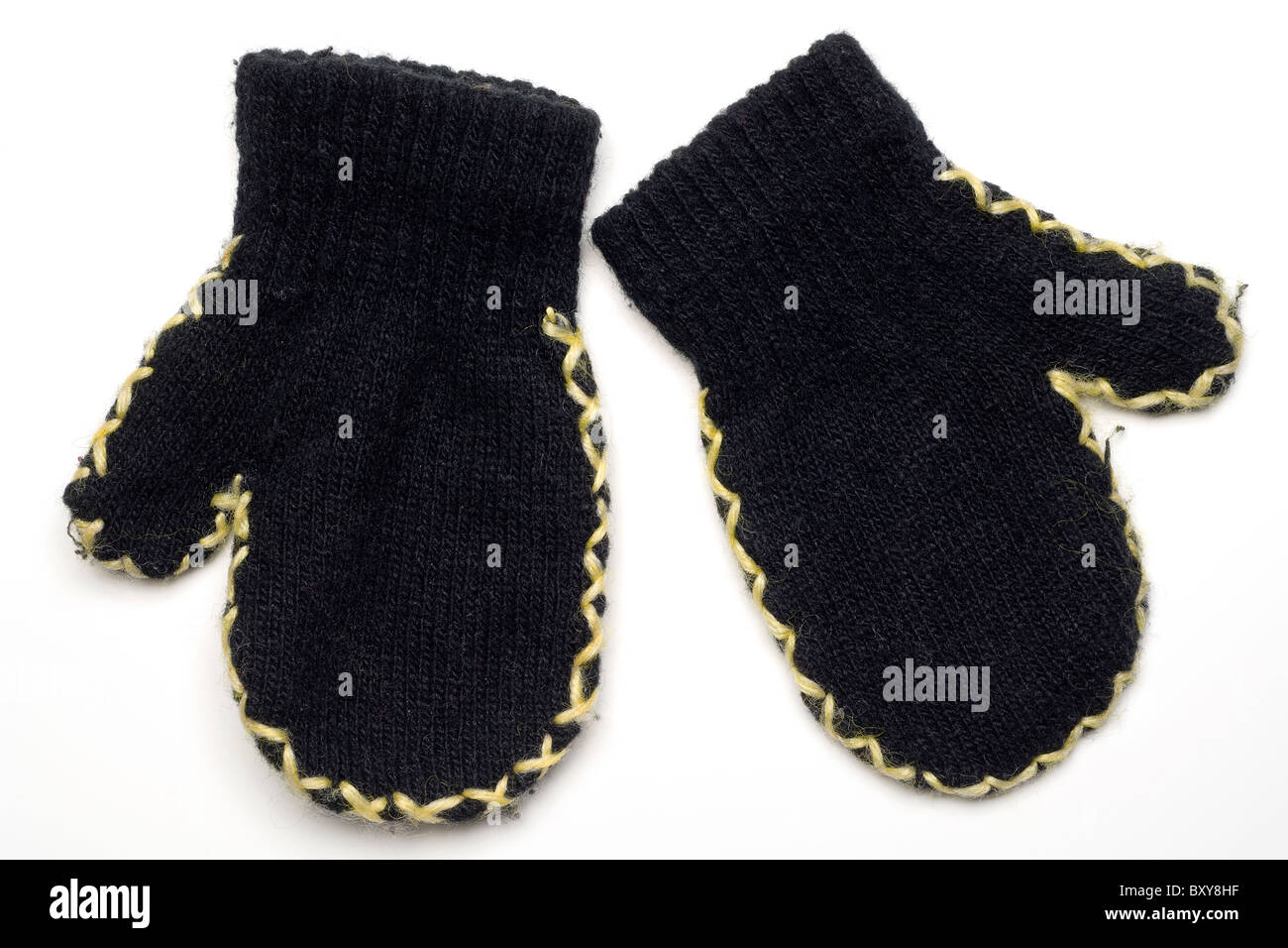 Une paire de mitaines en laine noir sur blanc de l'enfant Banque D'Images