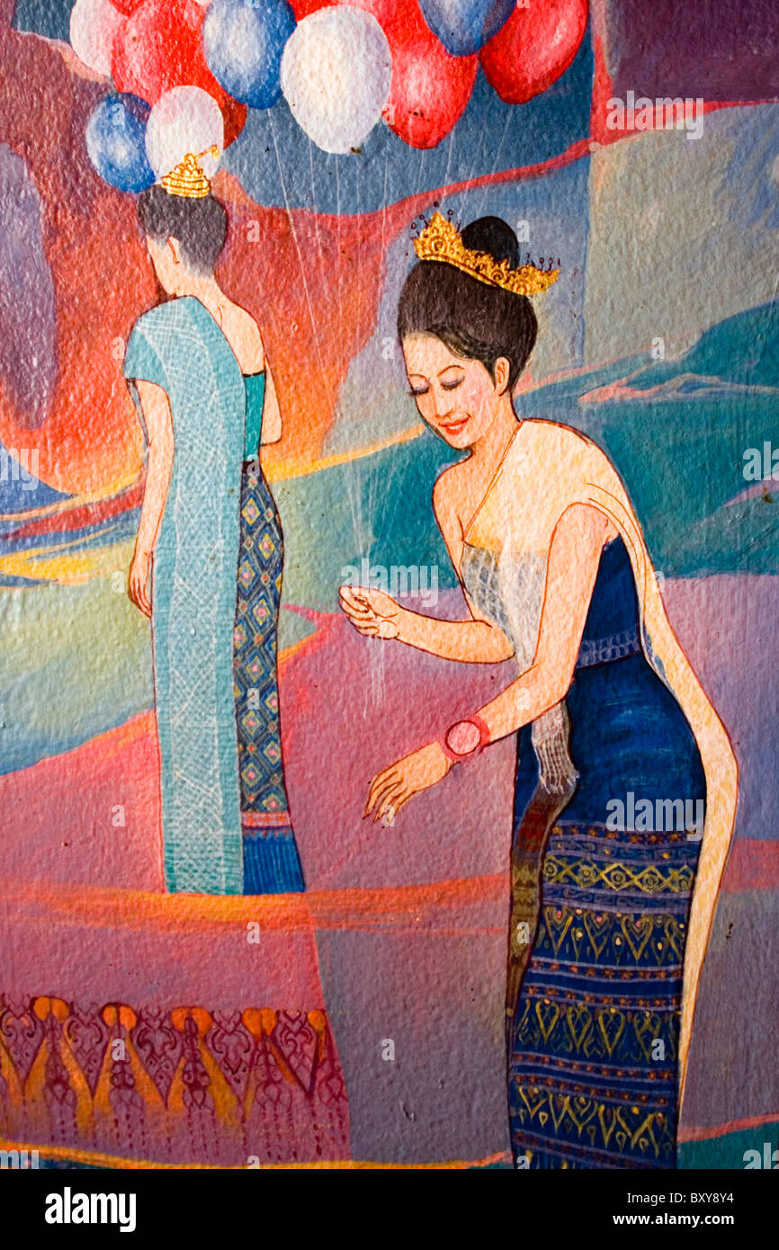 Une vieille peinture bouddhiste coloré et des femmes avec des ballons décore un temple de Nong Kai, en Thaïlande. Banque D'Images
