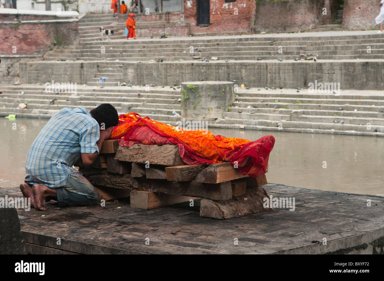 Un fils dit au revoir à un salon funéraire crémation sur la rivière Bagmati au Temple d'Pahsupatinath à Katmandou, Népal Banque D'Images