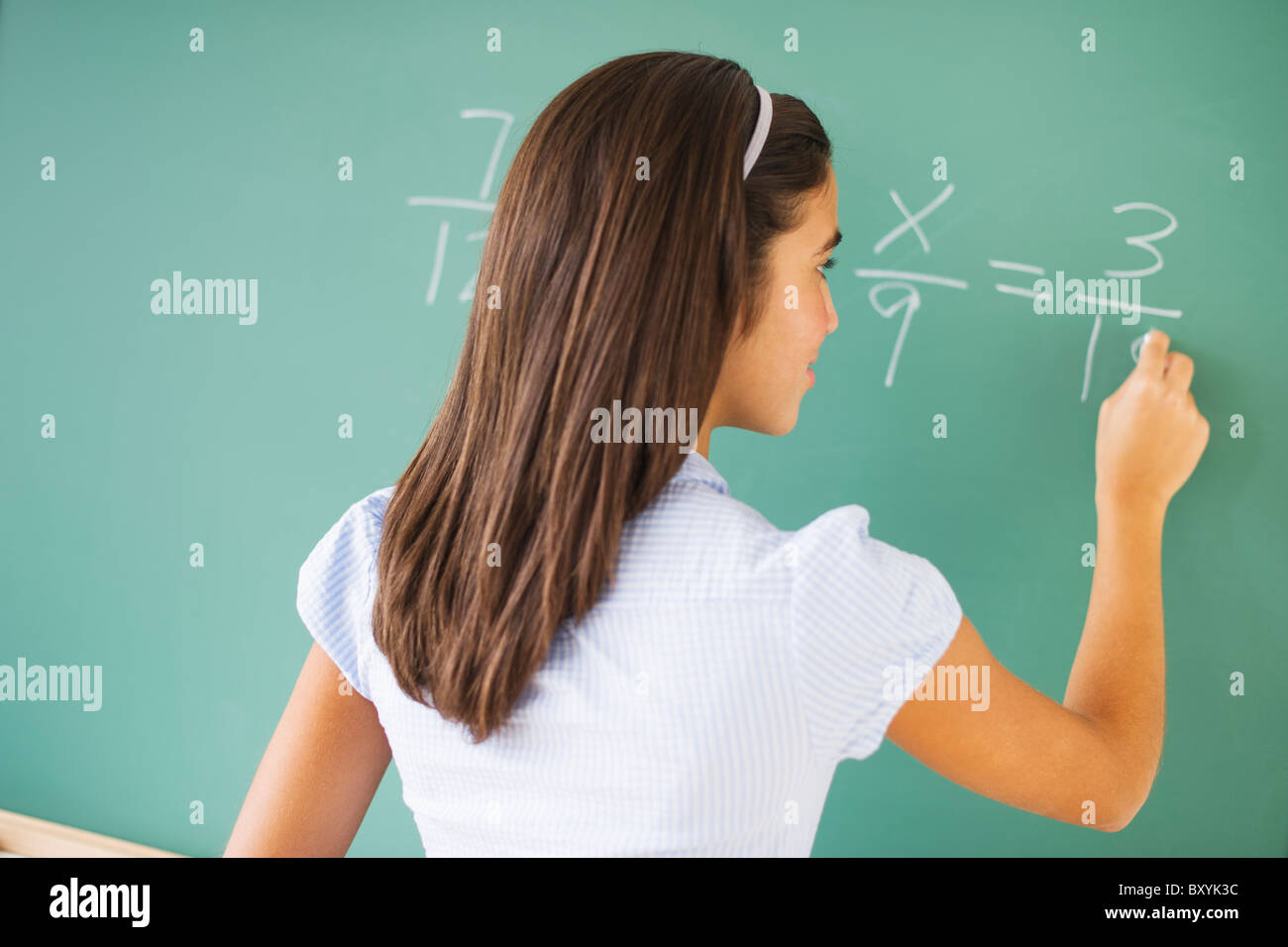 Girl écrit le tableau dans la classe Banque D'Images