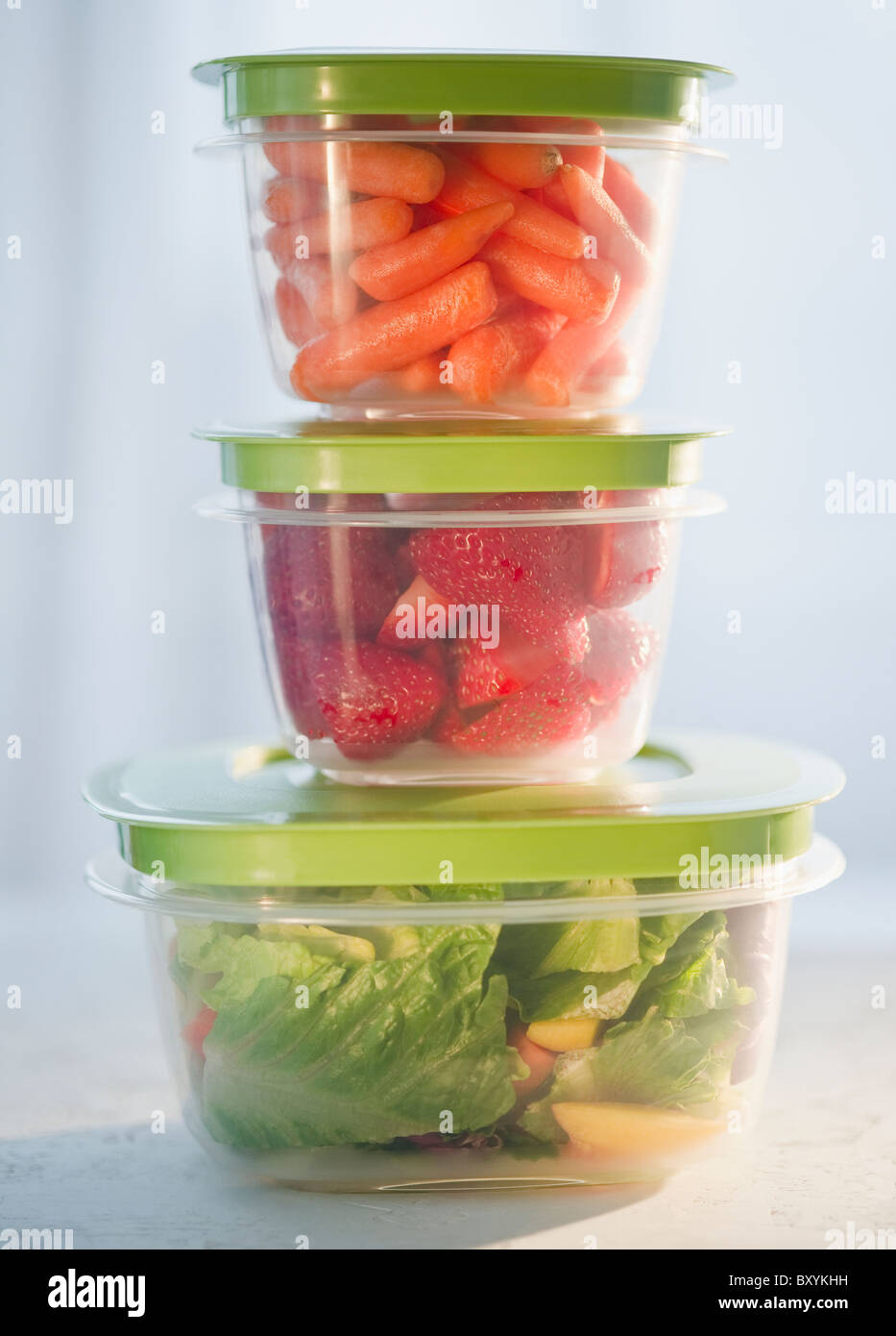 Des carottes, des fraises et de la salade dans des contenants en plastique, studio shot Banque D'Images