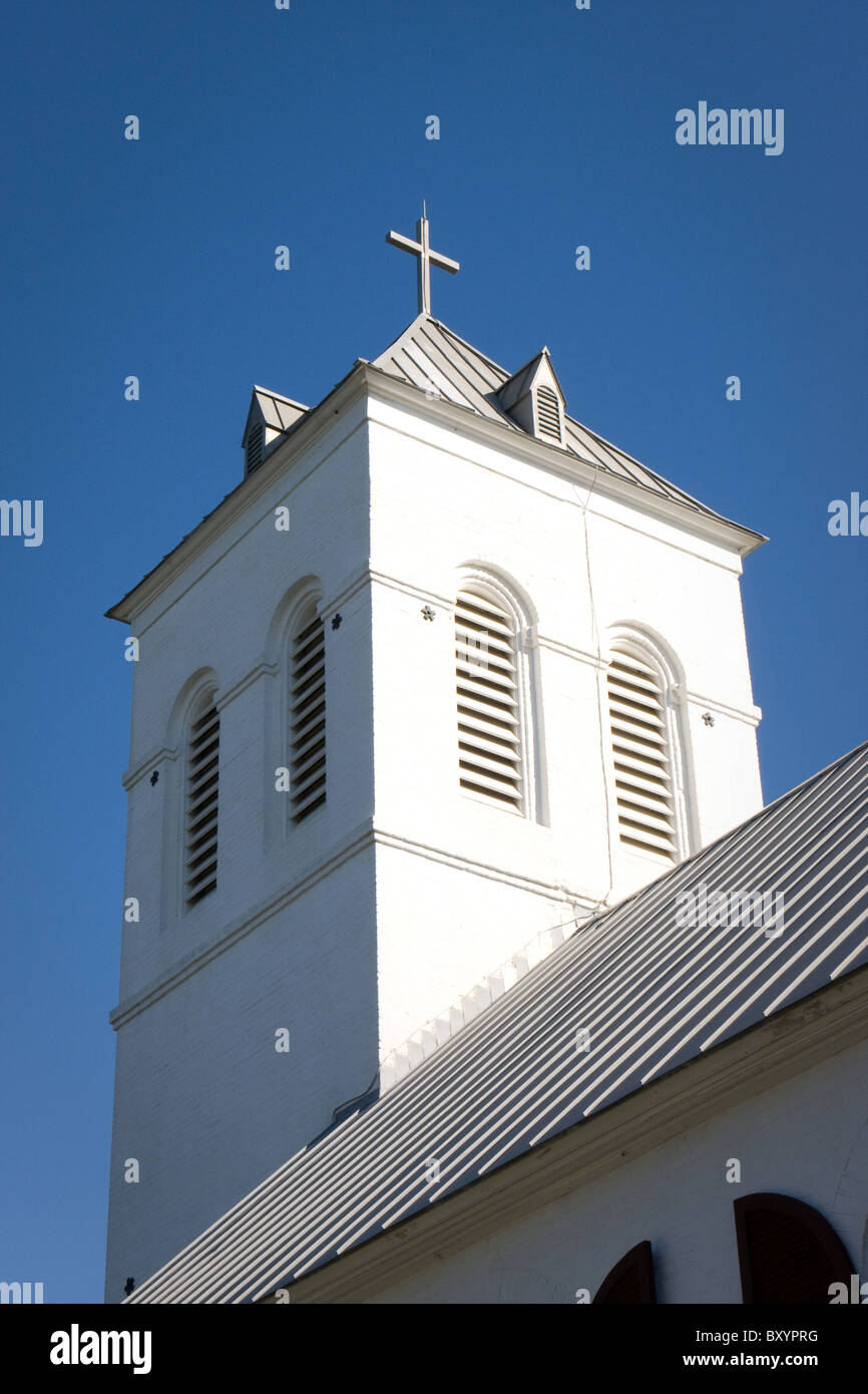 La croix blanche est situé en haut d'un clocher de l'église contre un ciel bleu. Banque D'Images