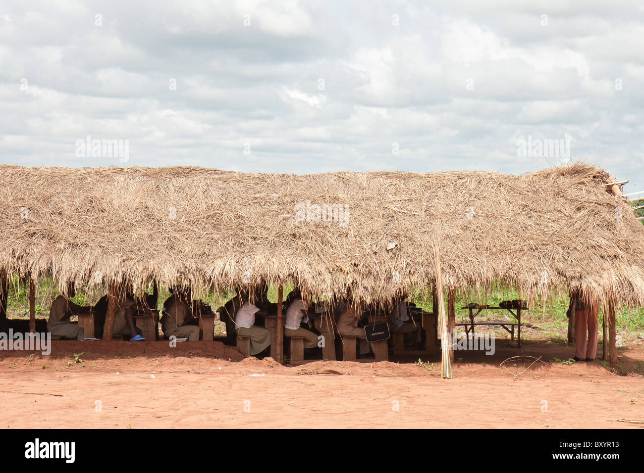 Un toit de chaume cabane dans un village de l'Afrique de l'Ouest est le lieu pour ces élèves de recevoir leur éducation. Banque D'Images