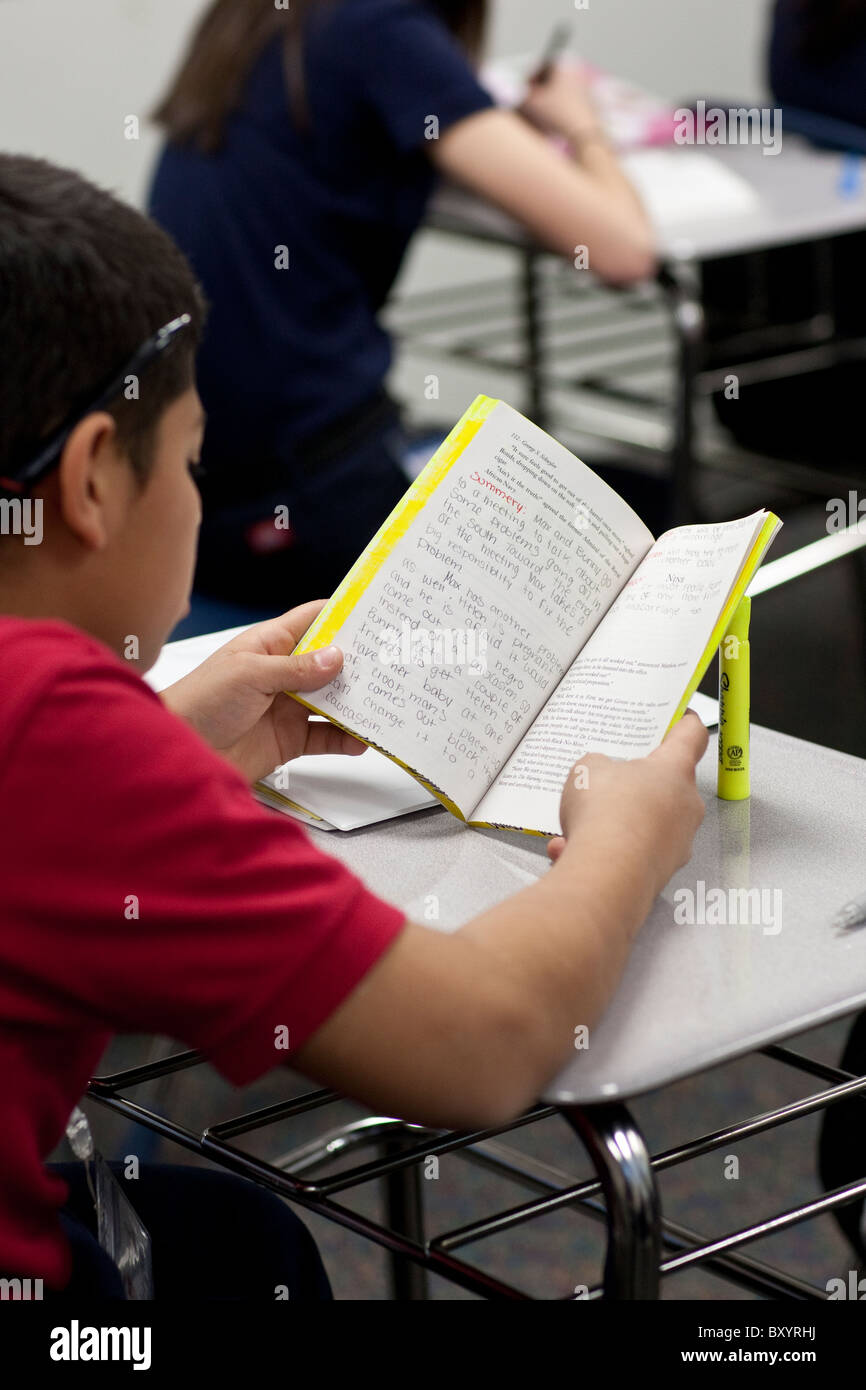 Boy lit un roman avec des annotations manuscrites en classe préparatoire au Sommet public charter high school Academy Banque D'Images