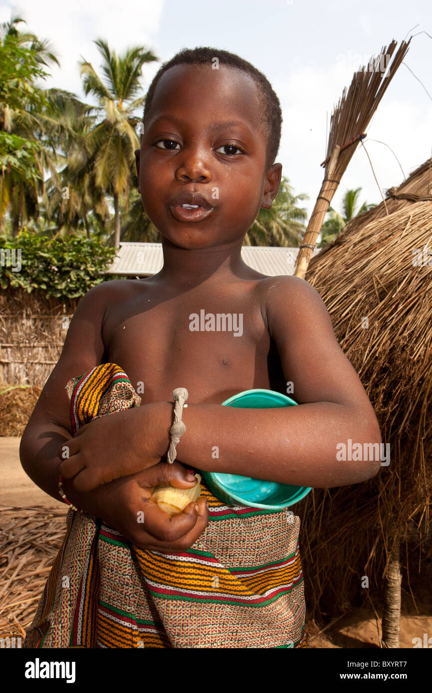 Un jeune garçon dont le village d'Afrique ont participé à un projet générateur de revenu pour améliorer la pauvreté rurale. Banque D'Images