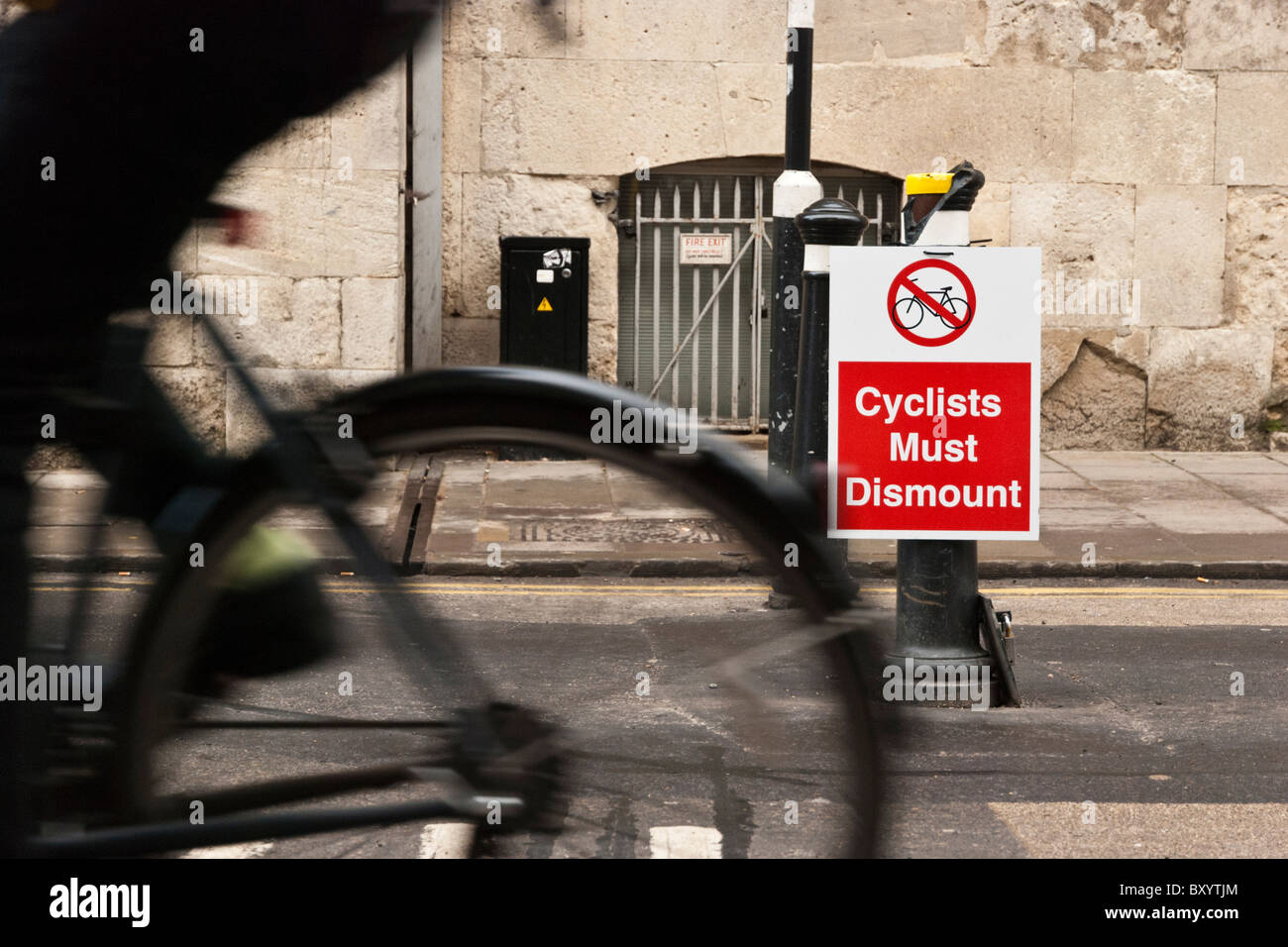 Circonscription cycliste passé une commande signe les cyclistes à démonter dans Broad Street, Oxford, Oxfordshire, Angleterre. Banque D'Images