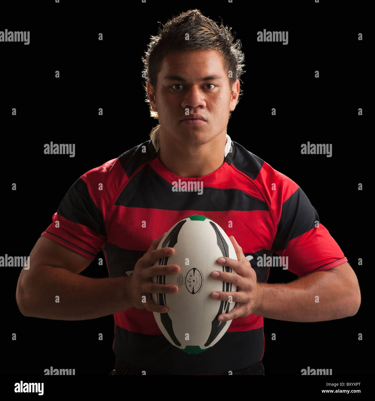 Studio portrait of male rugby player holding ball Banque D'Images