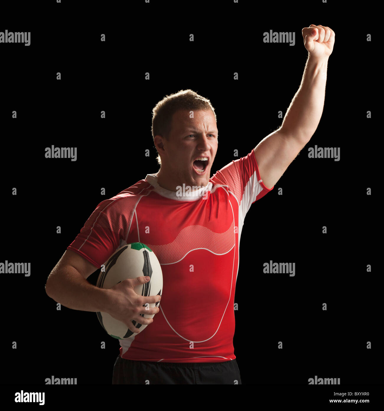 Homme rugby player holding ball, célébrer Banque D'Images