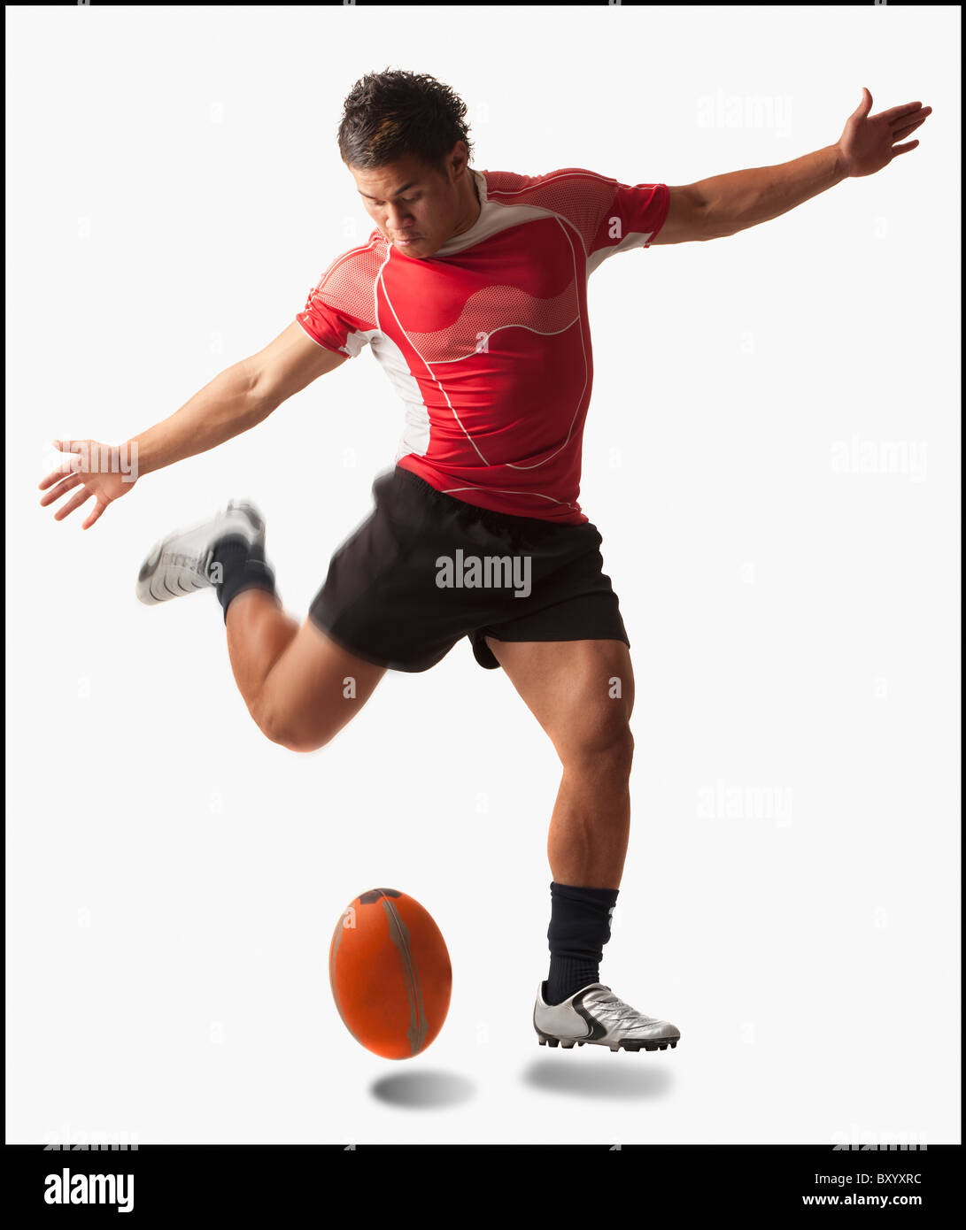 Rugby player kicking ball masculin Banque D'Images