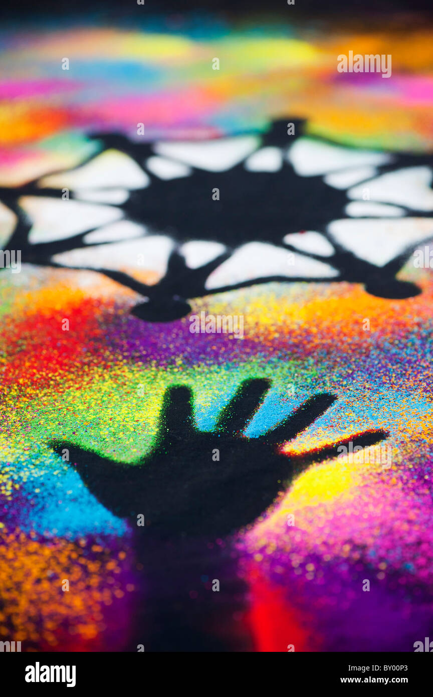 Un symbole d'unité mondiale entouré par la main des enfants d'impressions réalisées avec poudre multicolore Banque D'Images