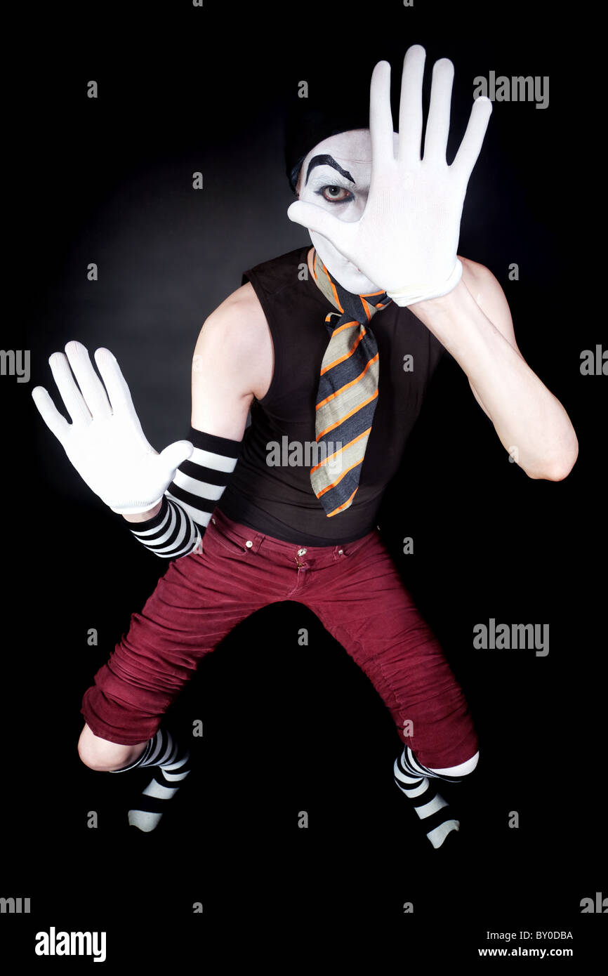 Mime drôle en gants blancs sur fond noir Banque D'Images