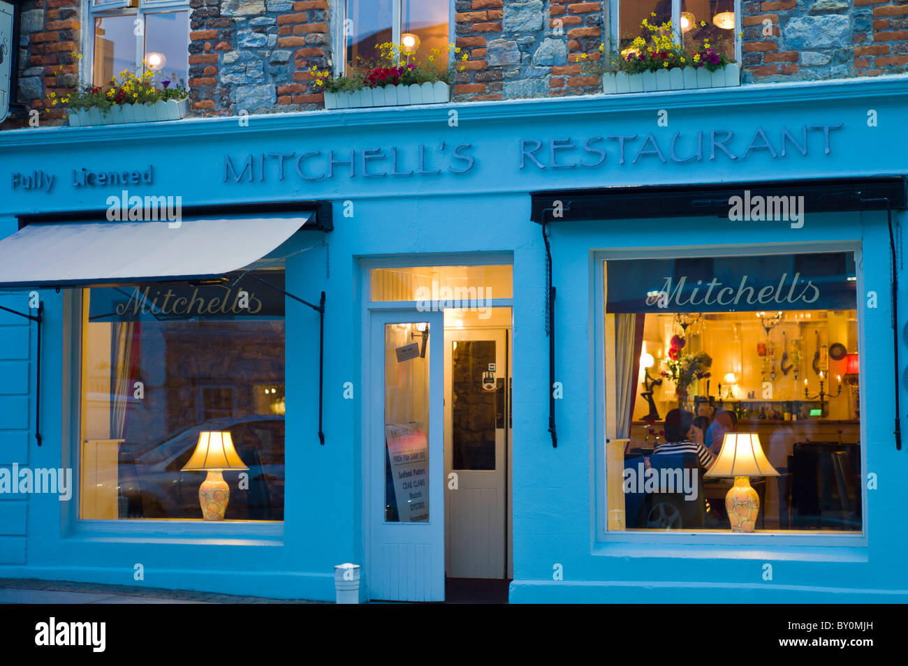 Mitchell's seafood restaurant éclairé à la lueur des lampes, Clifden, Connemara, comté de Galway, Irlande Banque D'Images
