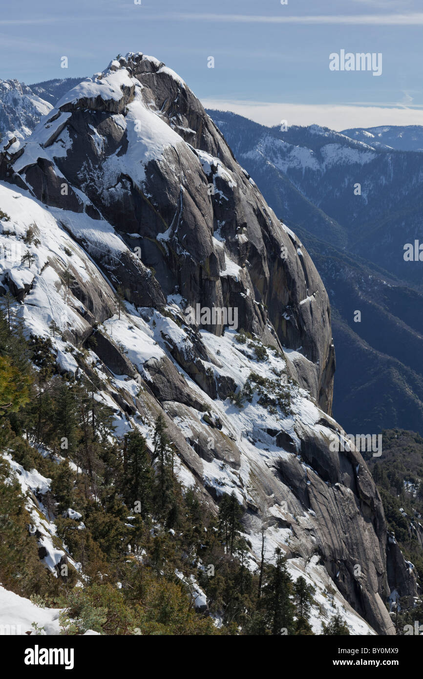 Grande vue de profil de Moro Rock dans le Sequoia National Park recouvert de neige sur un jour lumineux avec quelques nuages. Banque D'Images