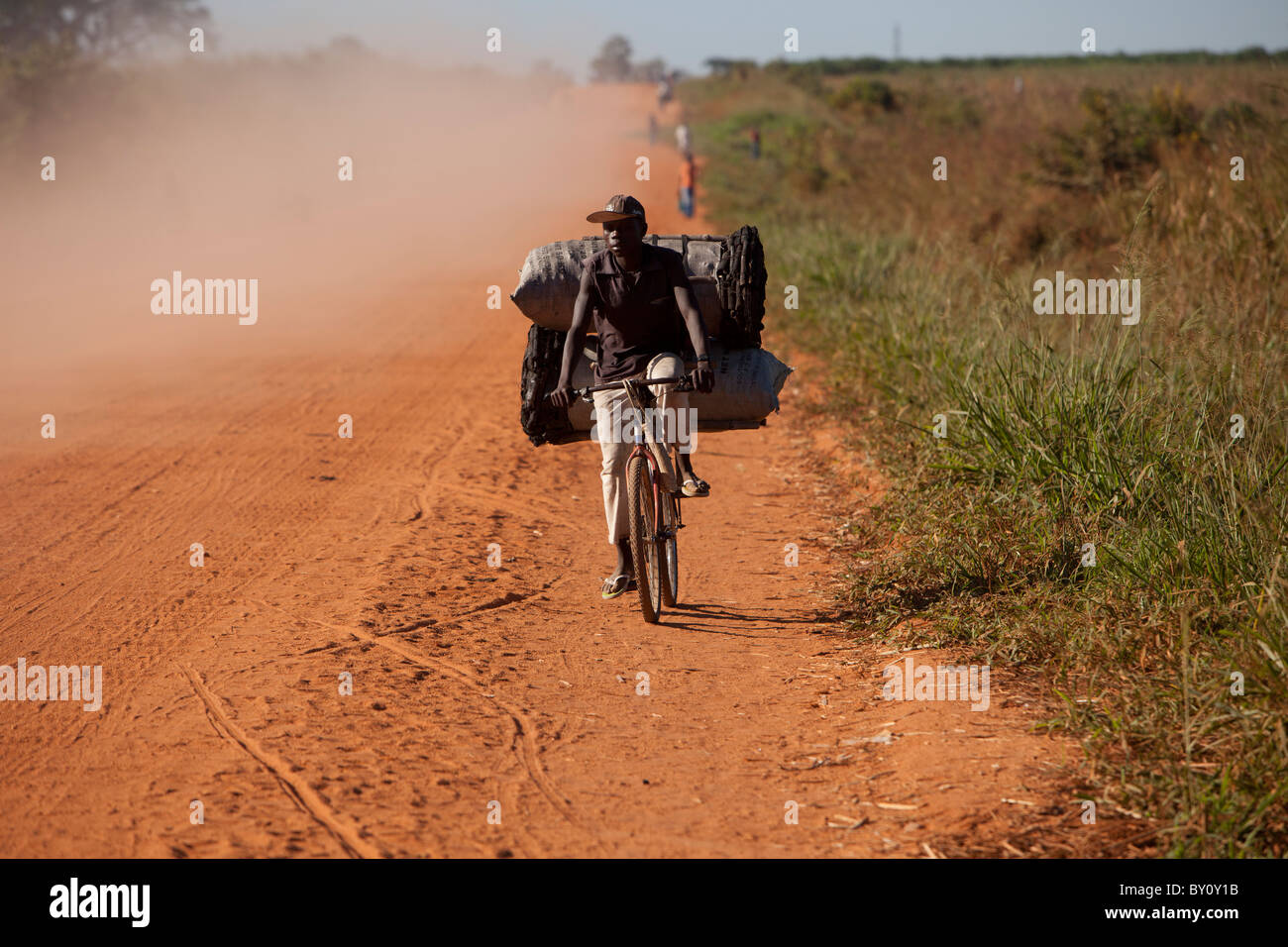 NAMPULA, MOZAMBIQUE, Mai 2010 : Mettre le charbon de la ville en vélo. Un sac de charbon se vend à 100 Mt, (environ 3,00). Banque D'Images