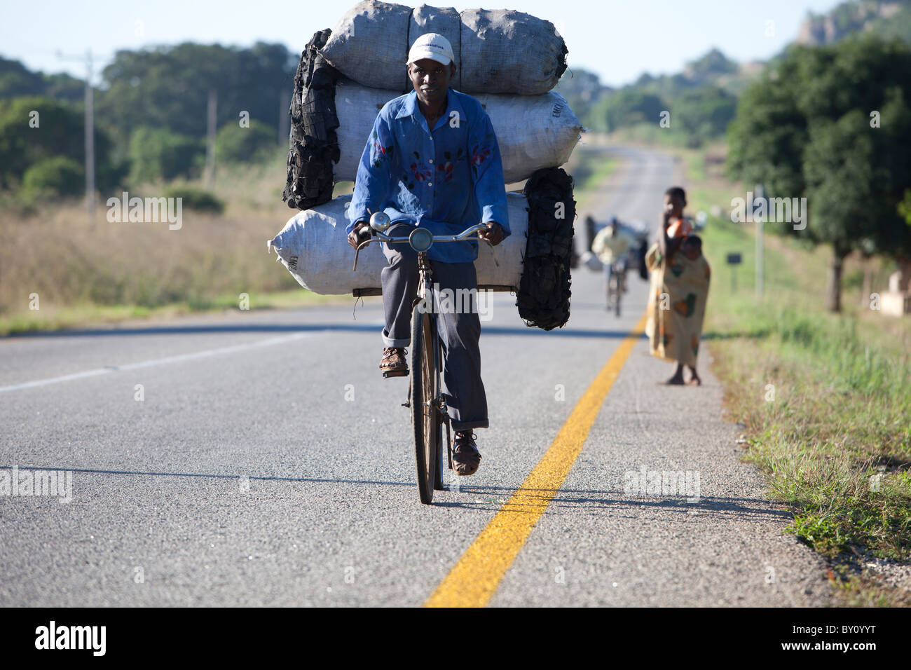 MUECATE Forêt, Près de Nampula, MOZAMBIQUE, Mai 2010 : rapprocher le charbon à Nampula en vélo. Un sac de charbon se vend à 100 Mt. Banque D'Images