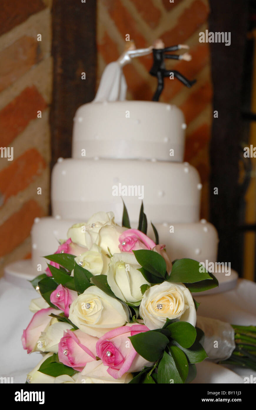 Un bouquet de roses mariage gâteau de mariage avec en arrière-plan avec la caricature drôle à la réception de la décolleteuse Banque D'Images