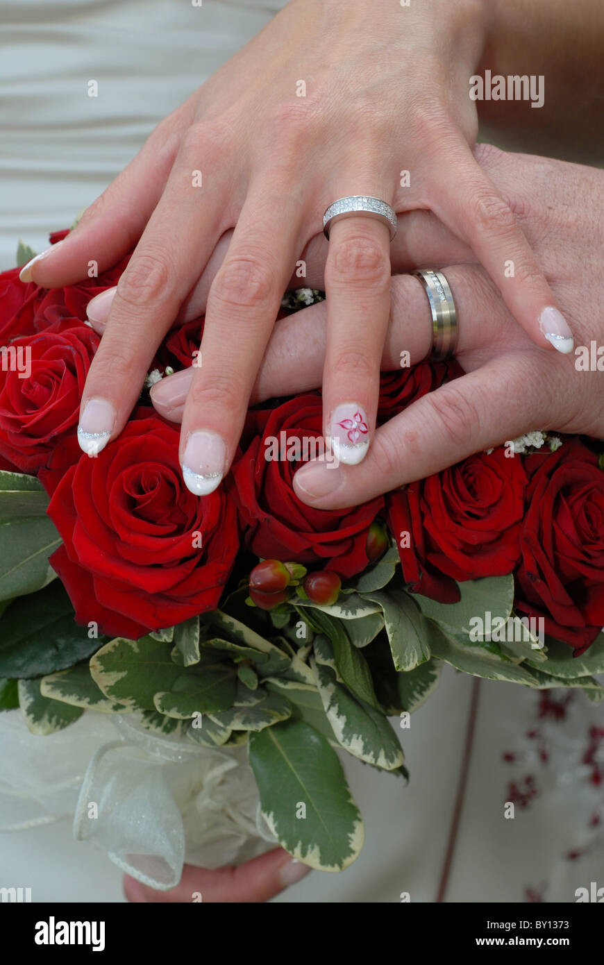 Mariée et le Marié mariage le jour de leur mariage en appui sur le bouquet de fleurs. Banque D'Images