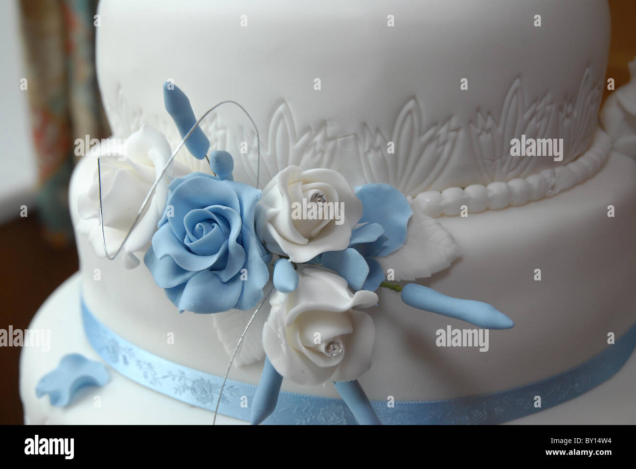 Général close up de bébé bleu et blanc roses fabriqués à partir de cerise sur un gâteau de mariage à la réception Banque D'Images