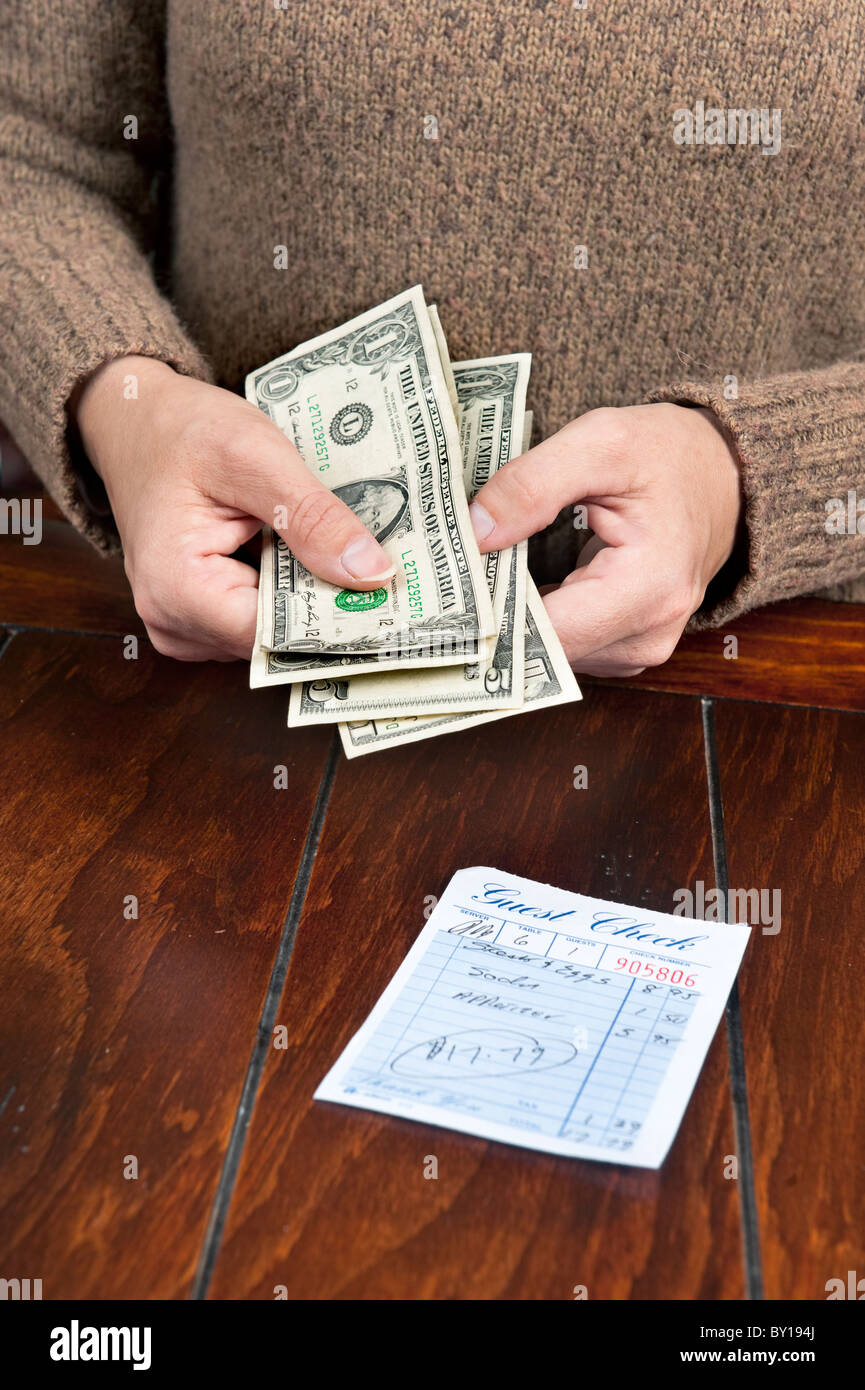 Une femme paie son repas bill avec de l'argent comptant. Banque D'Images