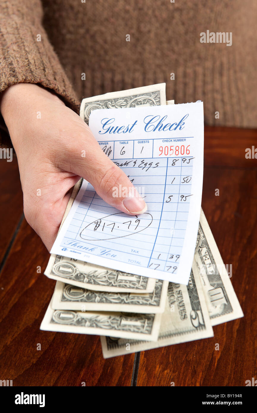 Une femme les mains sur le paiement pour un repas au restaurant, bill Banque D'Images