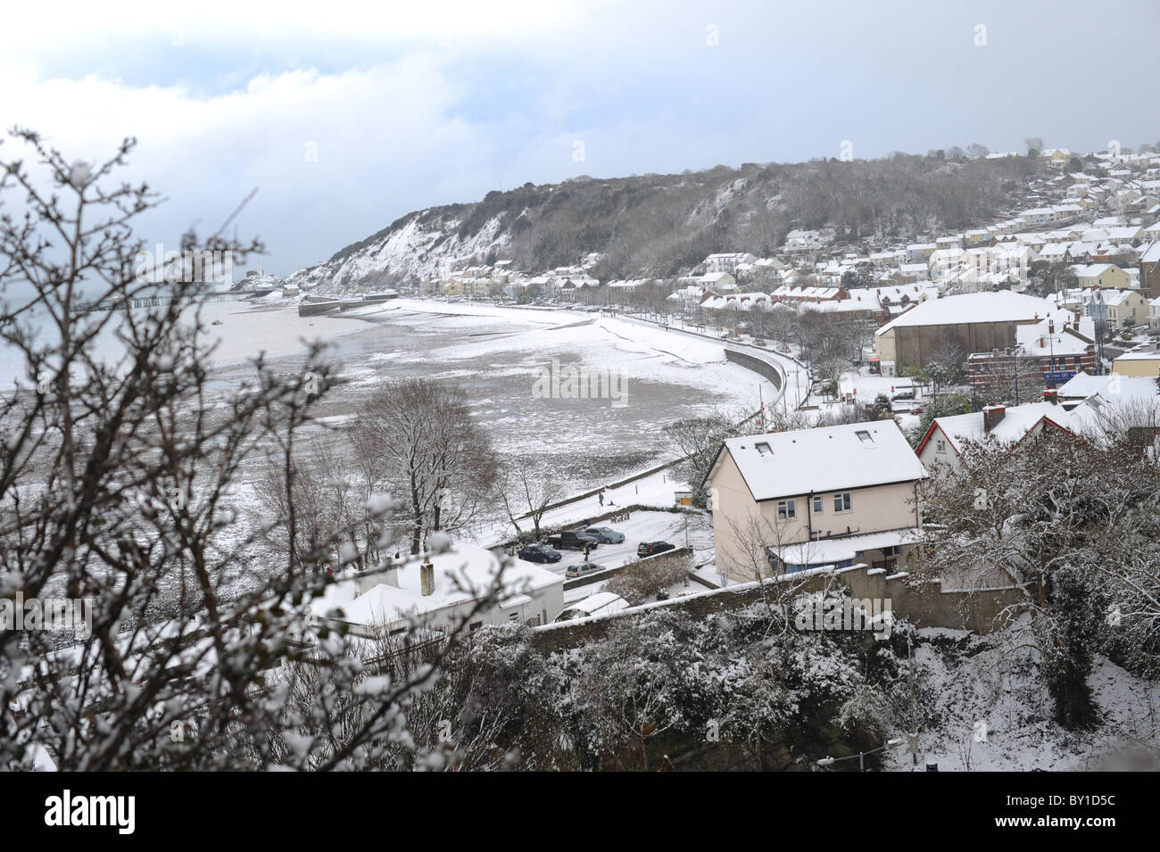 Village de Mumbles et bay après de fortes chutes de neige. De sombres nuages à l'horizon et de la neige jusqu'à la mer. Mumbles a été voté meilleur endroit pour vivre au pays de Galles en 2018. Banque D'Images