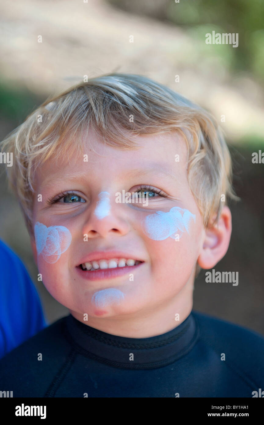 Portrait de jeune garçon australien avec blue crème solaire sur son visage Banque D'Images
