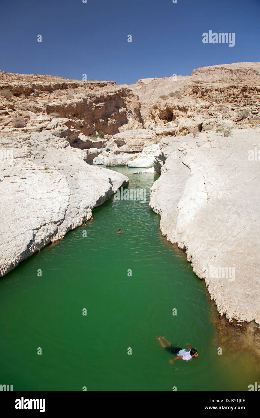 Oman, Wadi Bani Khalid. Enfants nagent dans les eaux douces, de Wadi Bani Khalid. Banque D'Images