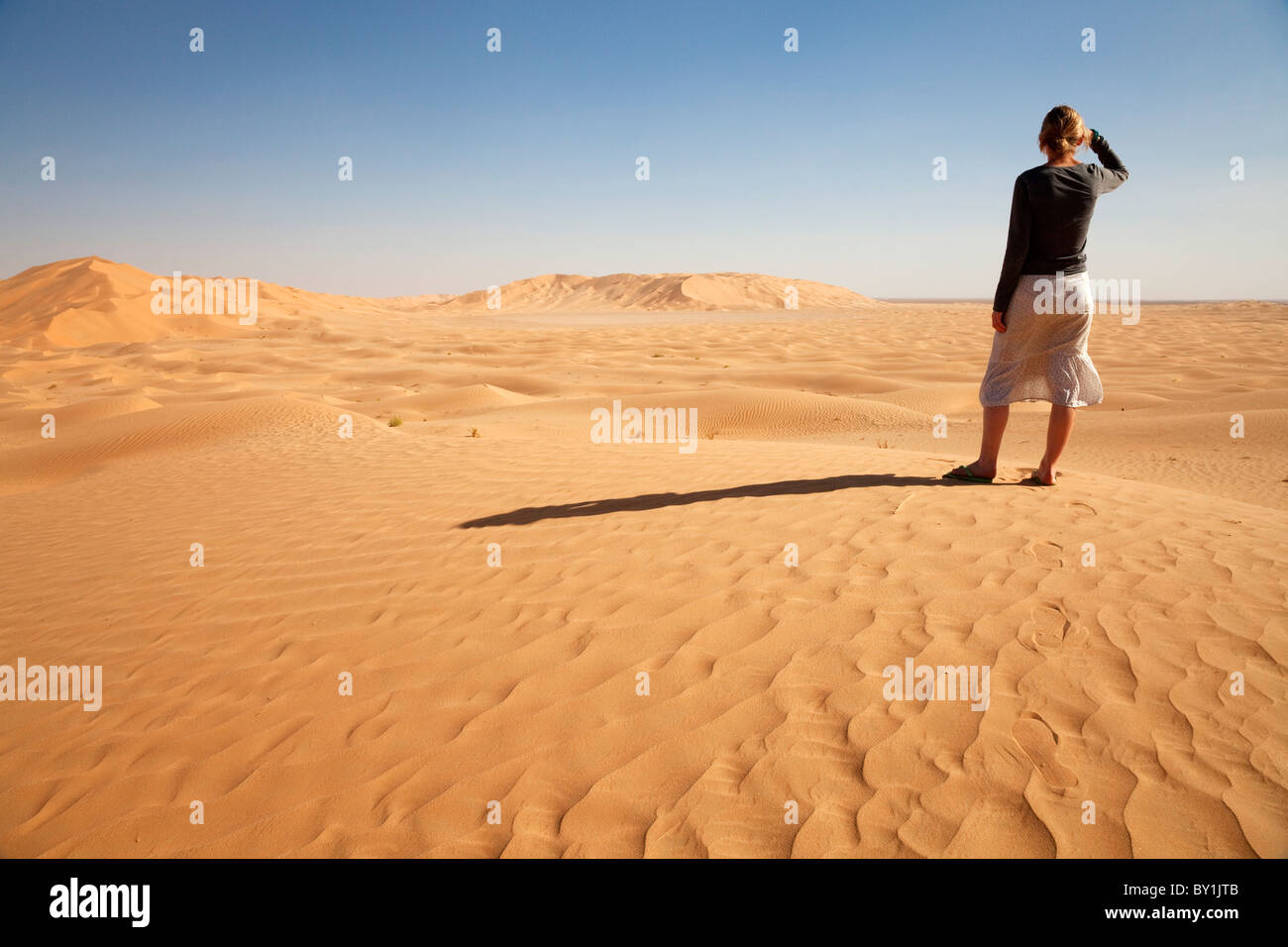 Oman, quart vide. Oman, quart vide. Une jeune femme debout à la crête d'une dune. M. Banque D'Images