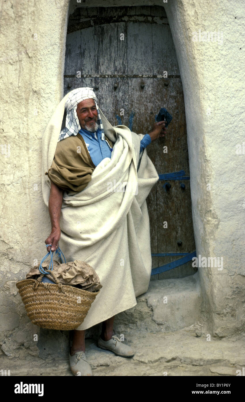 Un berbère en robe traditionnelle quitte sa maison pour faire du shopping à Chenini, Tunisie du Sud 1984 Banque D'Images