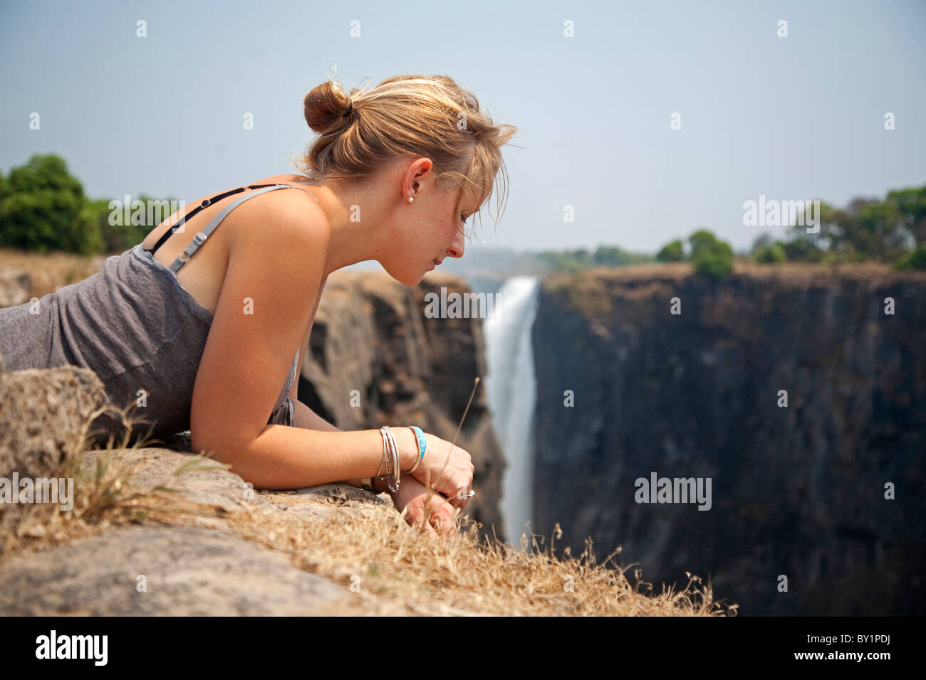 Le Zimbabwe, les chutes Victoria. Une jeune femme pairs sur le bord des chutes Victoria. M. Banque D'Images