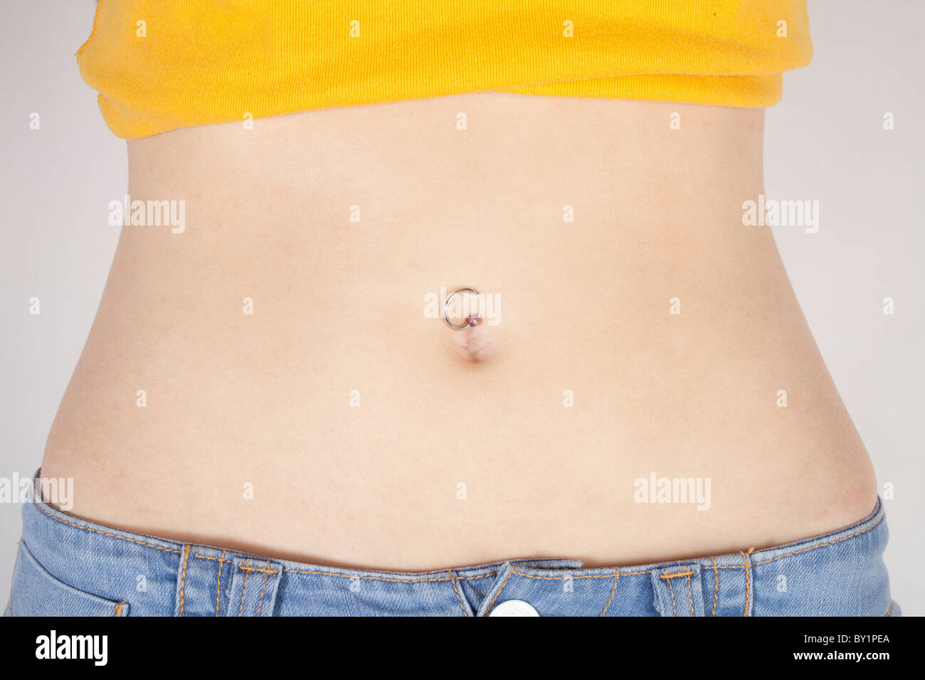 Piercing au nombril sur un corps de femme Photo Stock - Alamy