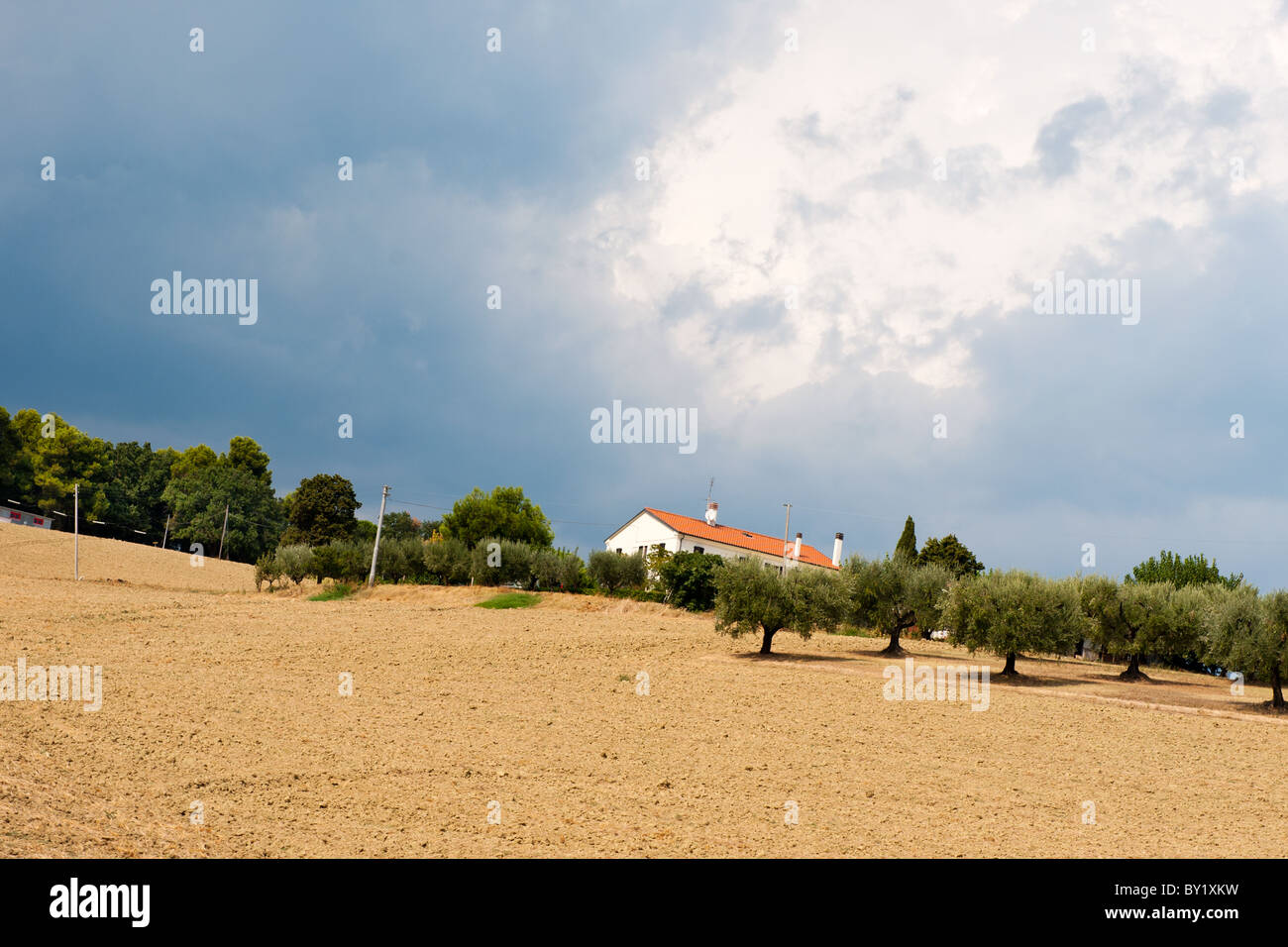 Ciel noir derrière un paysage italien avec une maison sur la colline Banque D'Images