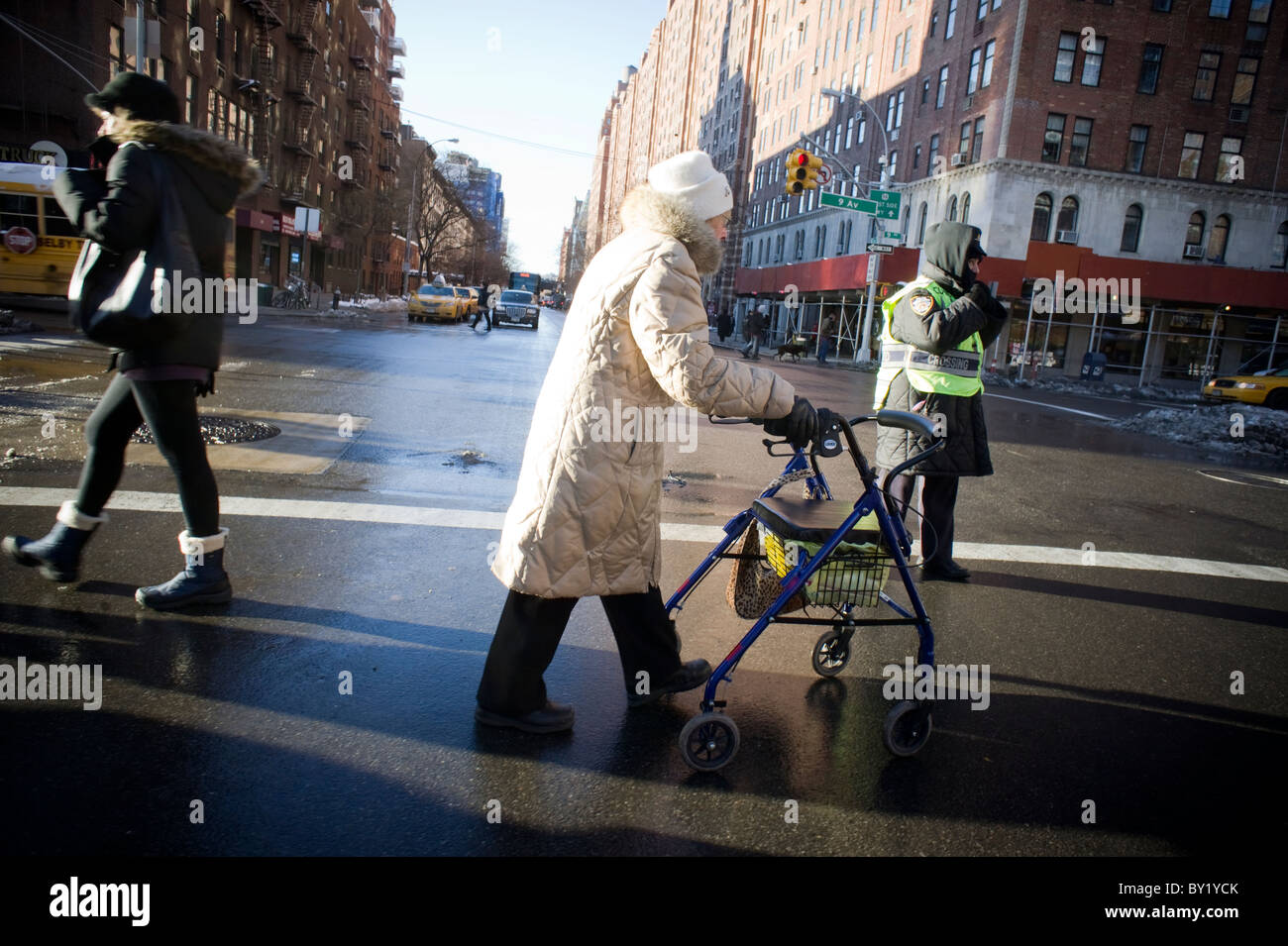 Une vieille femme traverse une intersection dangereuse dans le quartier de Chelsea à New York Banque D'Images