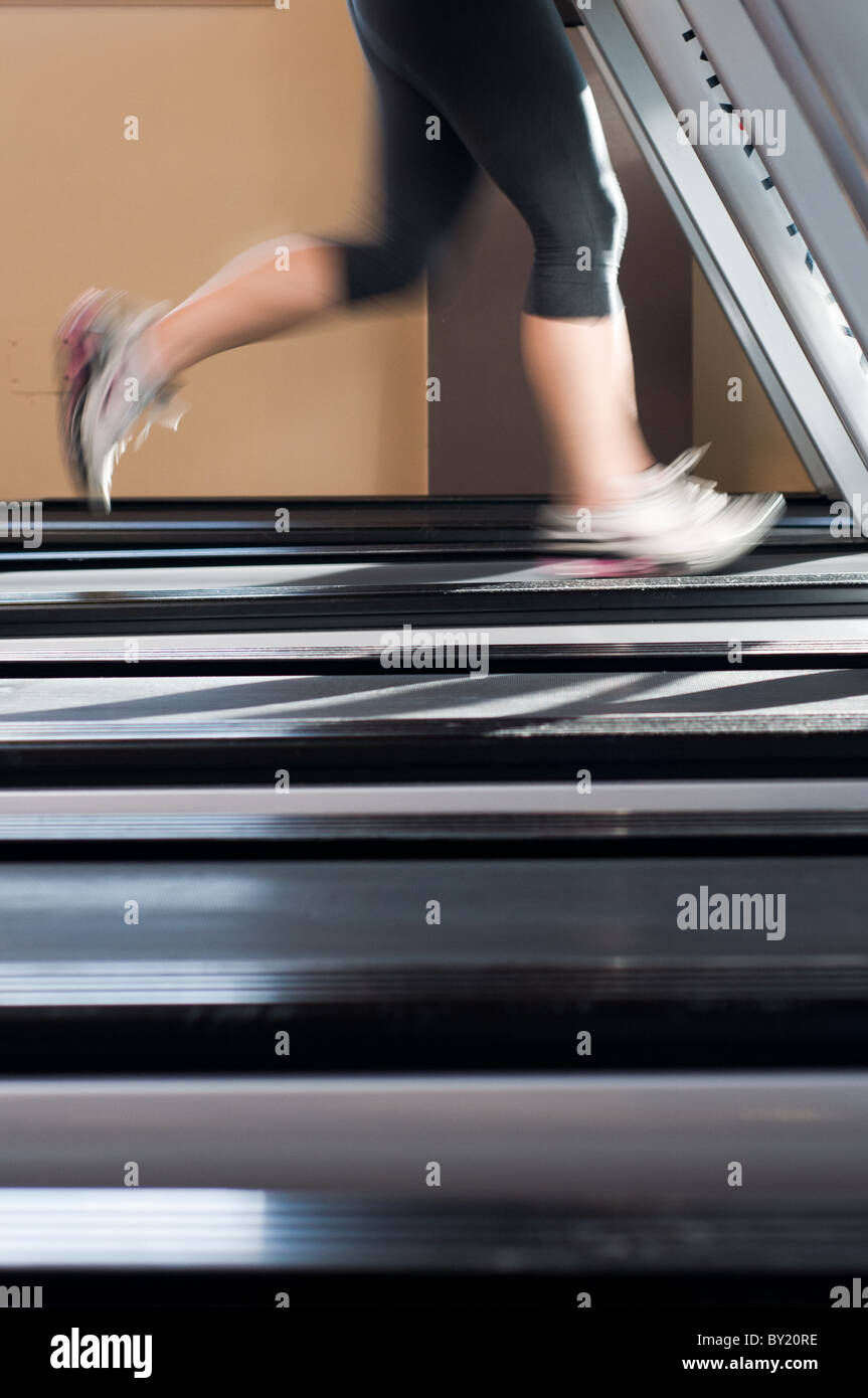 Femme d'exécution sur un tapis roulant Banque D'Images