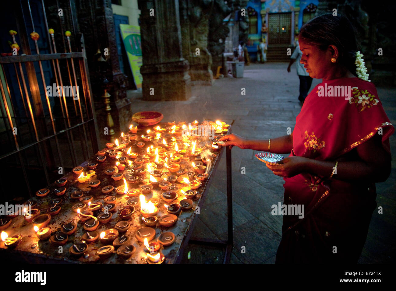 L'Inde, Madurai. Une femme fait une offrande au Temple Meenakshi Sundereshwara. Banque D'Images