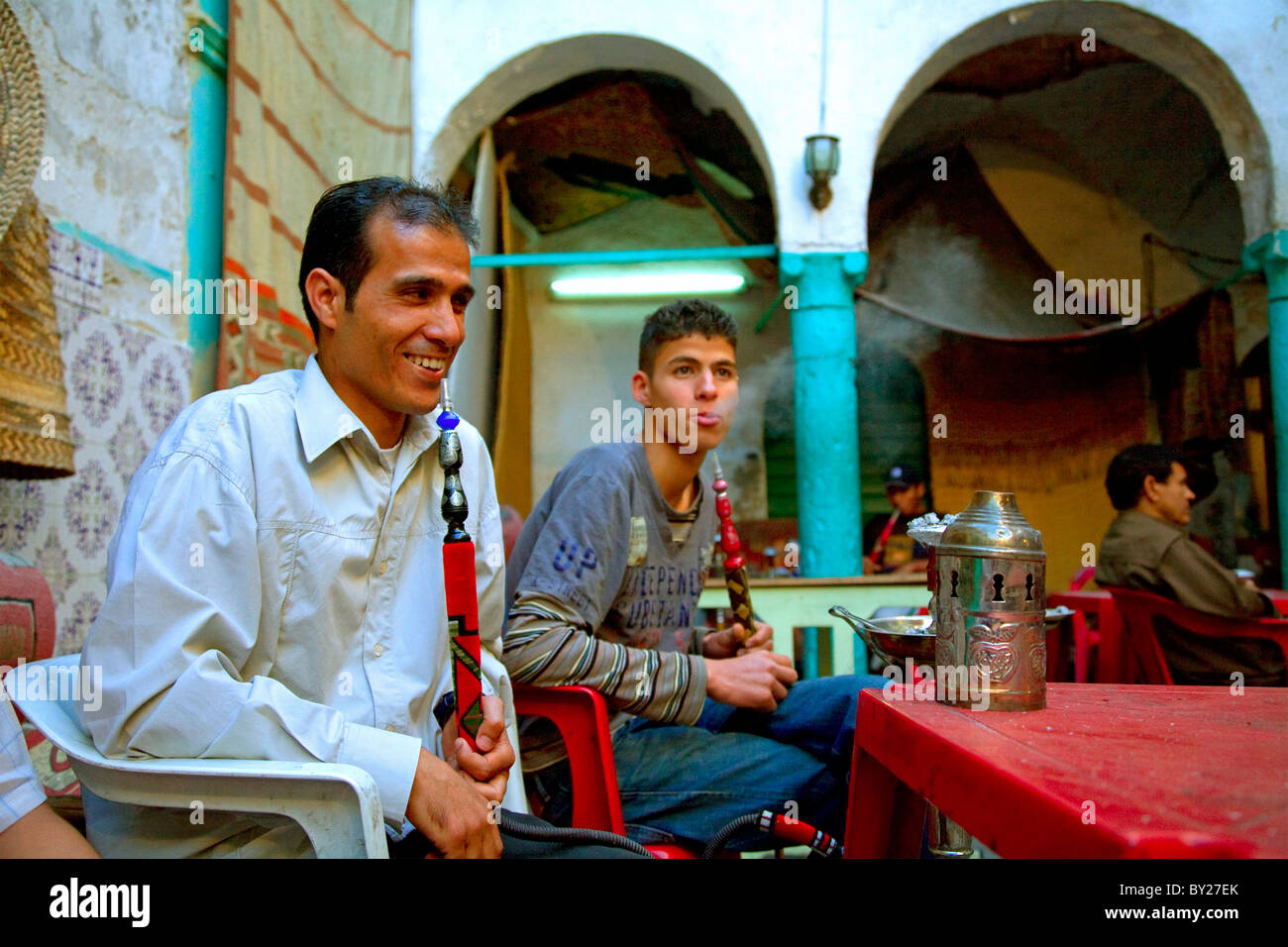 Tripoli (Libye) ; l'homme tuer le temps en jouant aux cartes, jeux en carton et fumer la chicha dans la cour d'un '13' qui funduq Banque D'Images