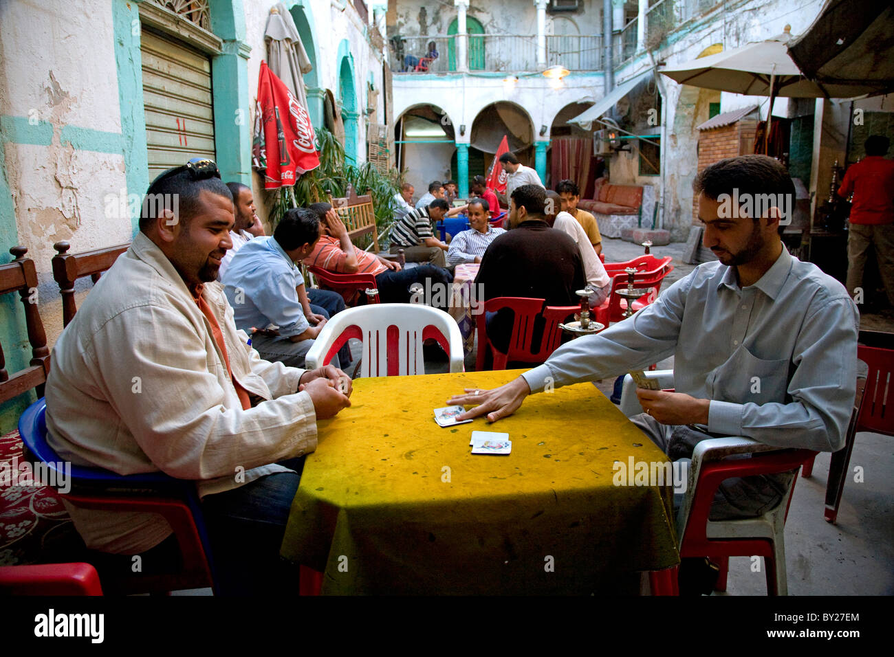 Tripoli (Libye) ; l'homme tuer le temps en jouant aux cartes, jeux en carton et fumer la chicha dans la cour d'un '13' qui funduq Banque D'Images