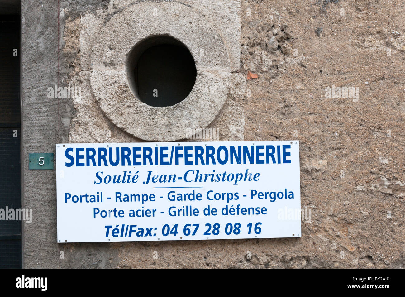 Un panneau dans un village français la publicité d'un fabricant de produits en fer. Banque D'Images