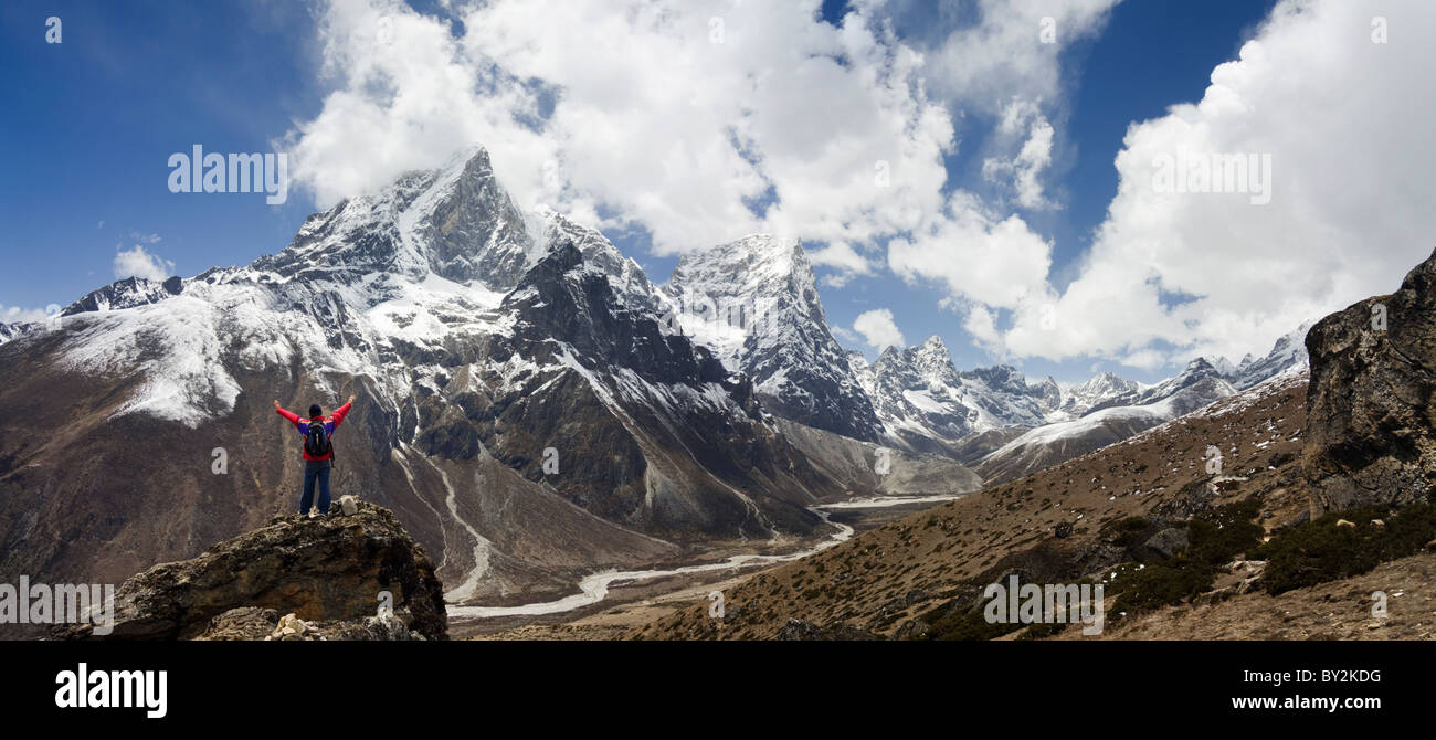 Un trekker bénéficie d'une vue sur le Taboche et le Cholatse le long du sentier de l'Everest, Khumu, région de l'Himalaya, au Népal. Banque D'Images