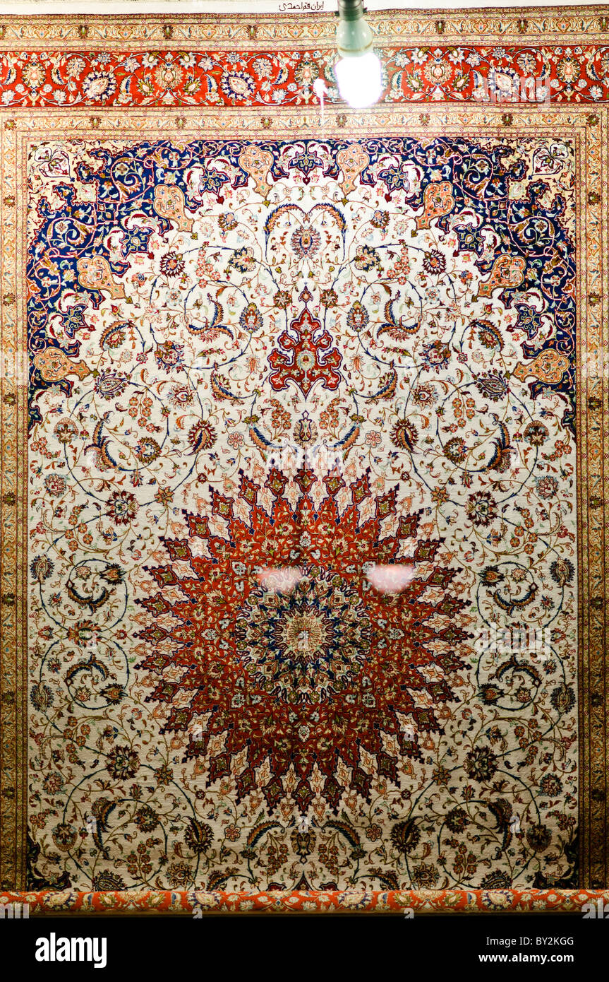 Vitrine de magasin de tapis turc ottoman Istanbul Turquie // ISTANBUL, Turquie — tapis turc orné de style ottoman exposé dans une vitrine dans le quartier Cankurtaran d'Istanbul. En haut du cadre se trouve la lumière de l'atelier, avec deux reflets sur le verre au centre du cadre. Banque D'Images