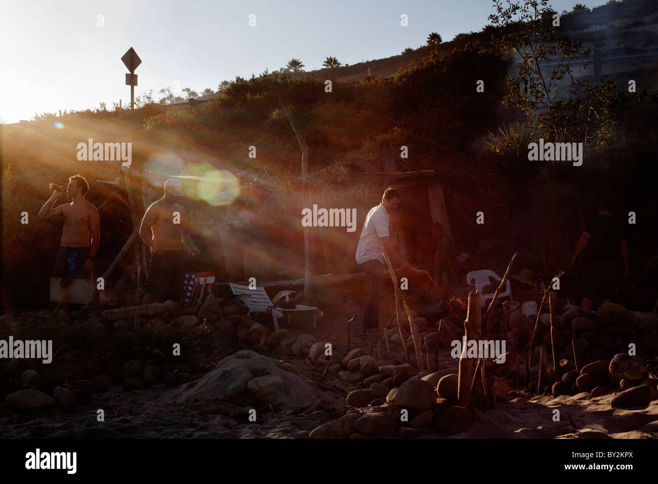 Trois amis profitez de la fin de l'après-midi et un feu de camp à Rincon Beach State Park près de Carpinteria, en Californie. Banque D'Images